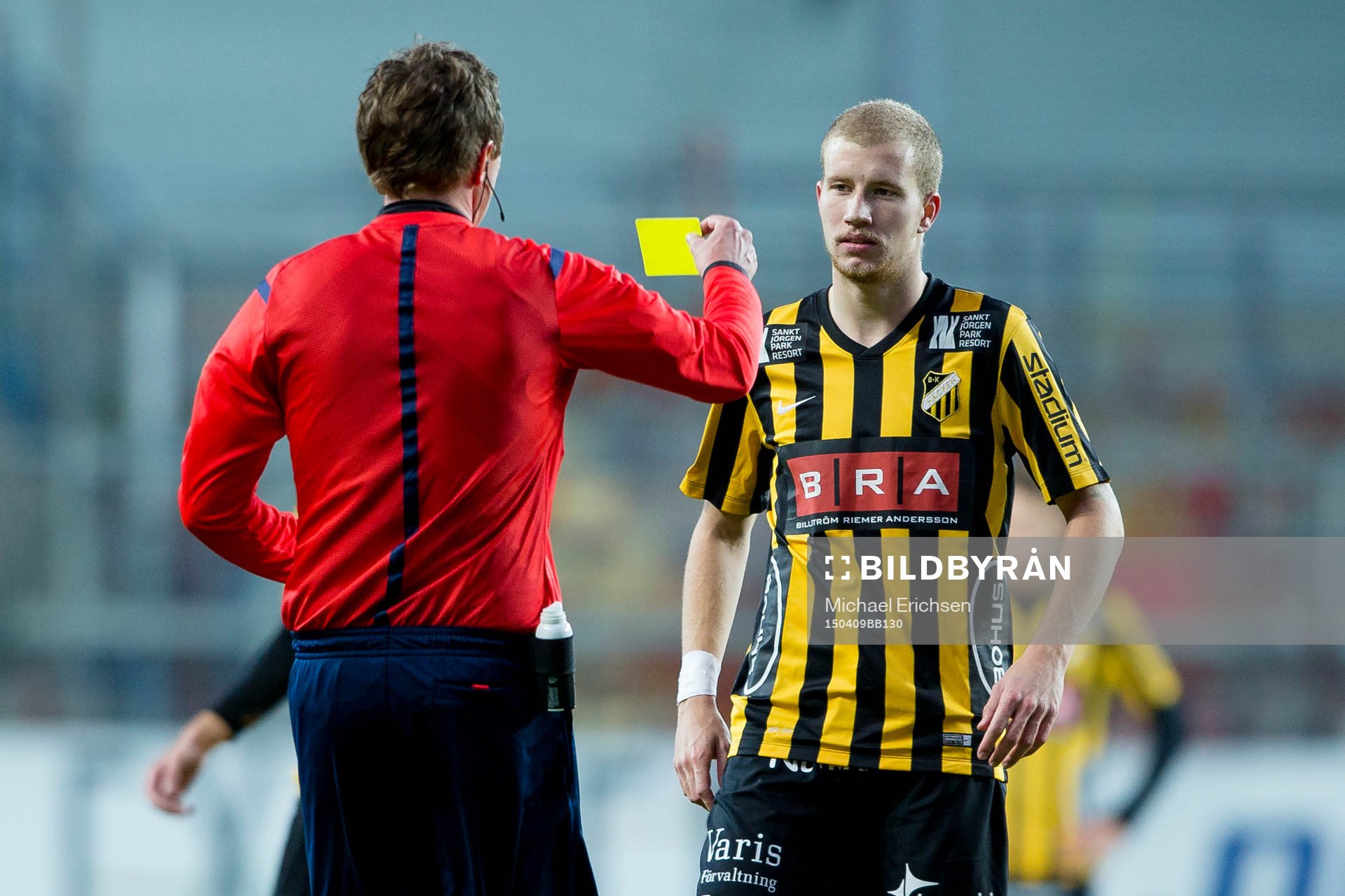 Domare Markus Strömbergsson delar ut ett gult kort till