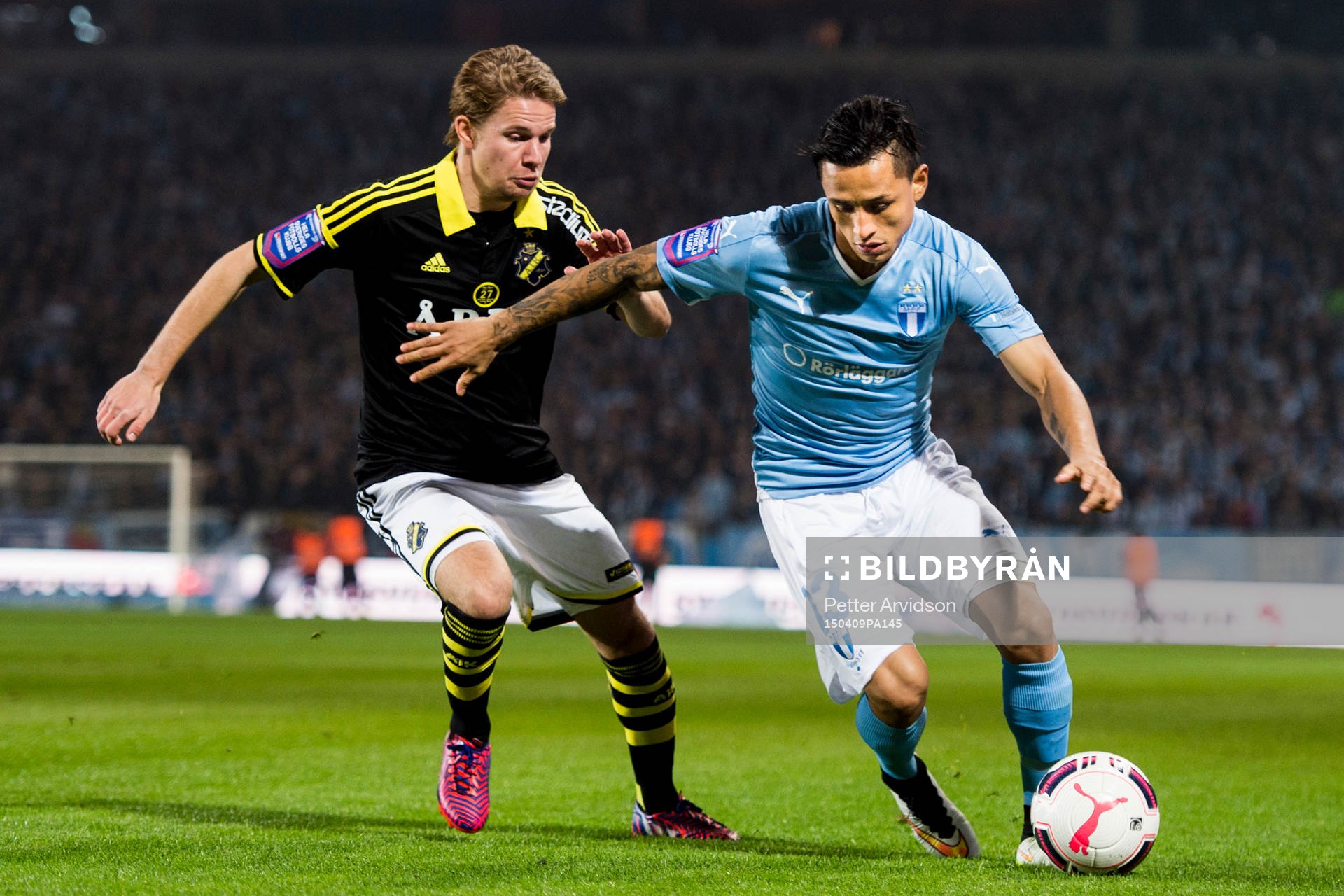 AIK:s Johan Blomberg och Malmö FFs Victor Yoshimar Yotun Flores under fotbollsmatchen i Allsvenskan mellan Malmö FF och AIK den 9 april 2015 i Malmö.