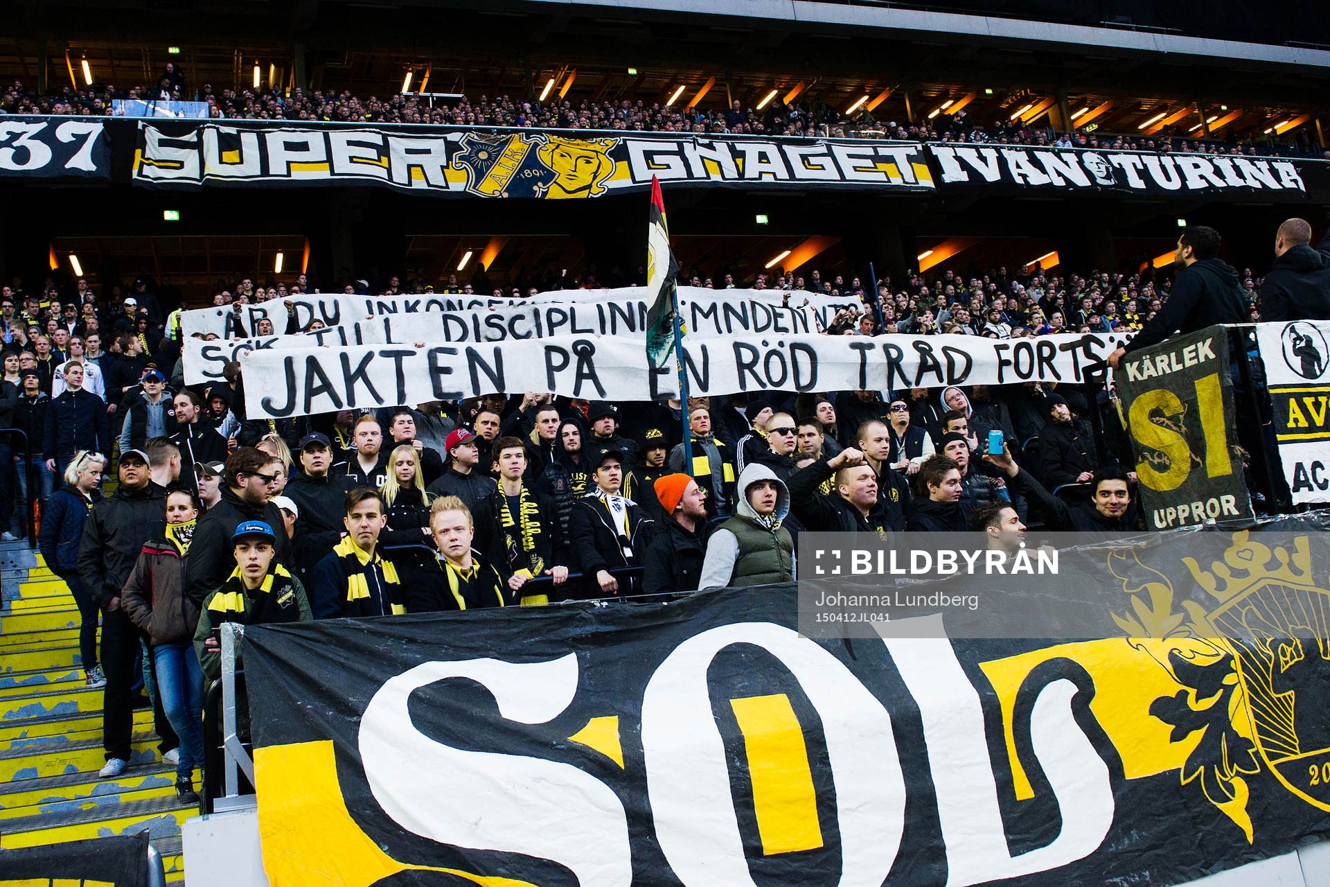 s supportrar håller upp banderoller som riktar kritik mot