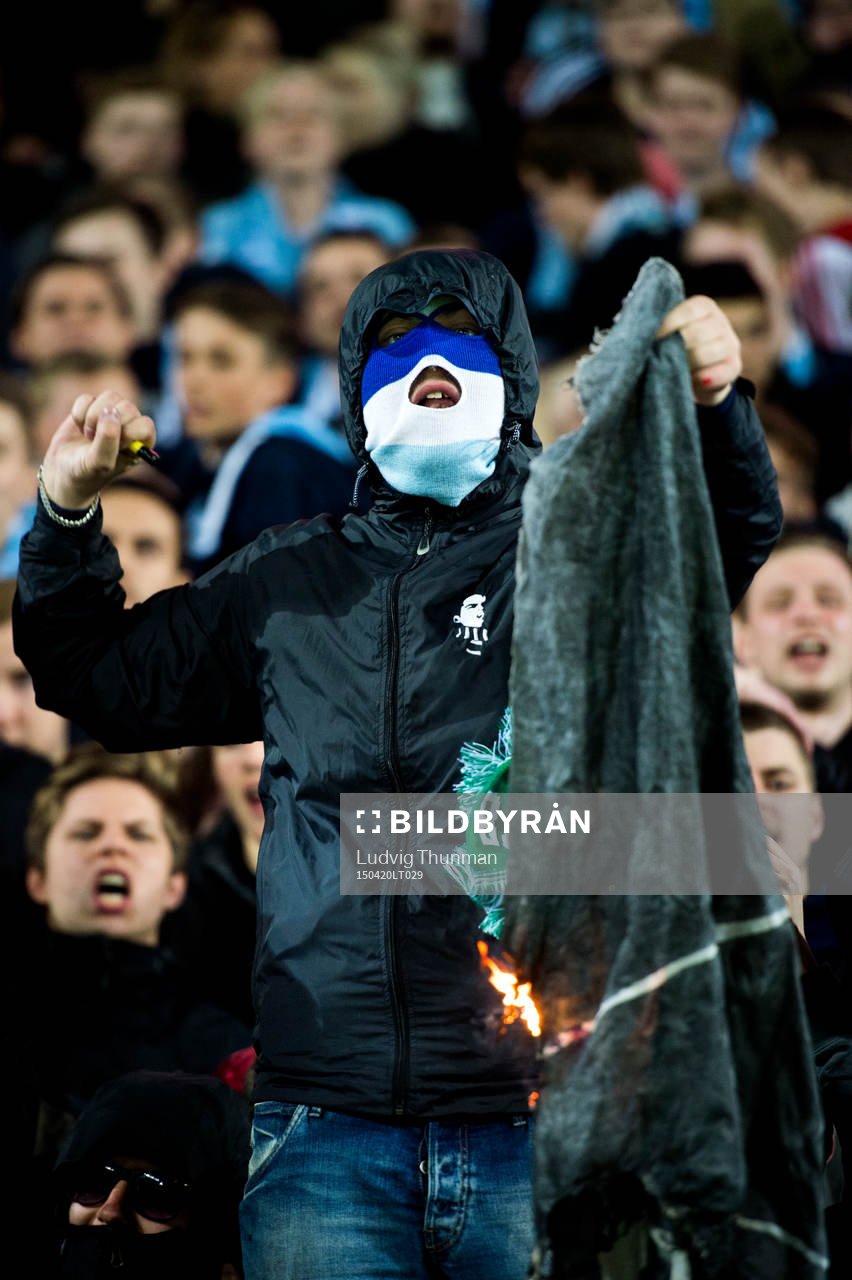En maskerad malmösupporter bränner Hammarbys flagga