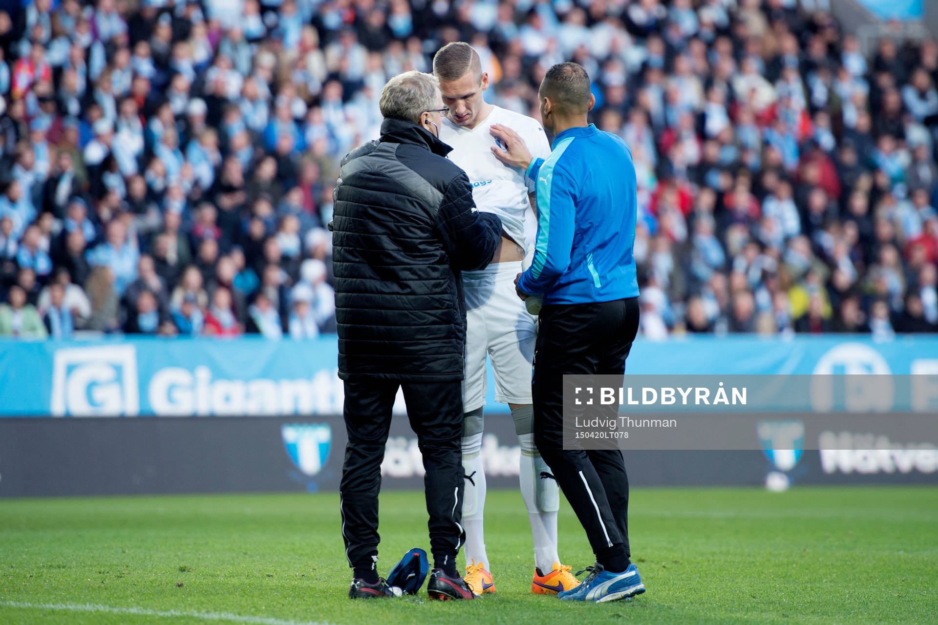 Malmö FFs målvakt Robin Olsen får pulsen och hjärtslagen kontrollerade av läkare Pär Herbertsson och naprapat Wilner Registre under fotbollsmatchen i Allsvenskan mellan Malmö FF och Hammarby den 20 april 2015 i Malmö.