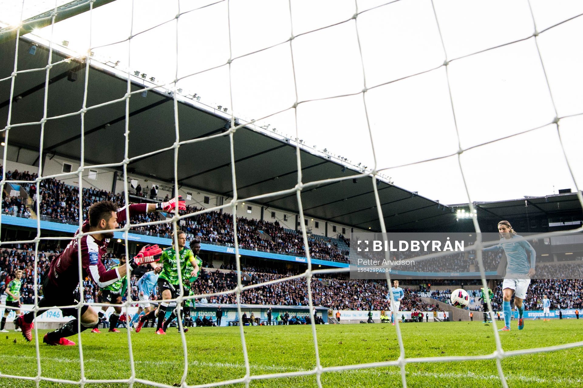 Malmö FFs Pawel Cibicki (th) gör 1-0 bakom Halmstads målvakt Stojan Lukic under fotbollsmatchen i Allsvenskan mellan Malmö FF och Halmstad den 29 april 2015 i Malmö.