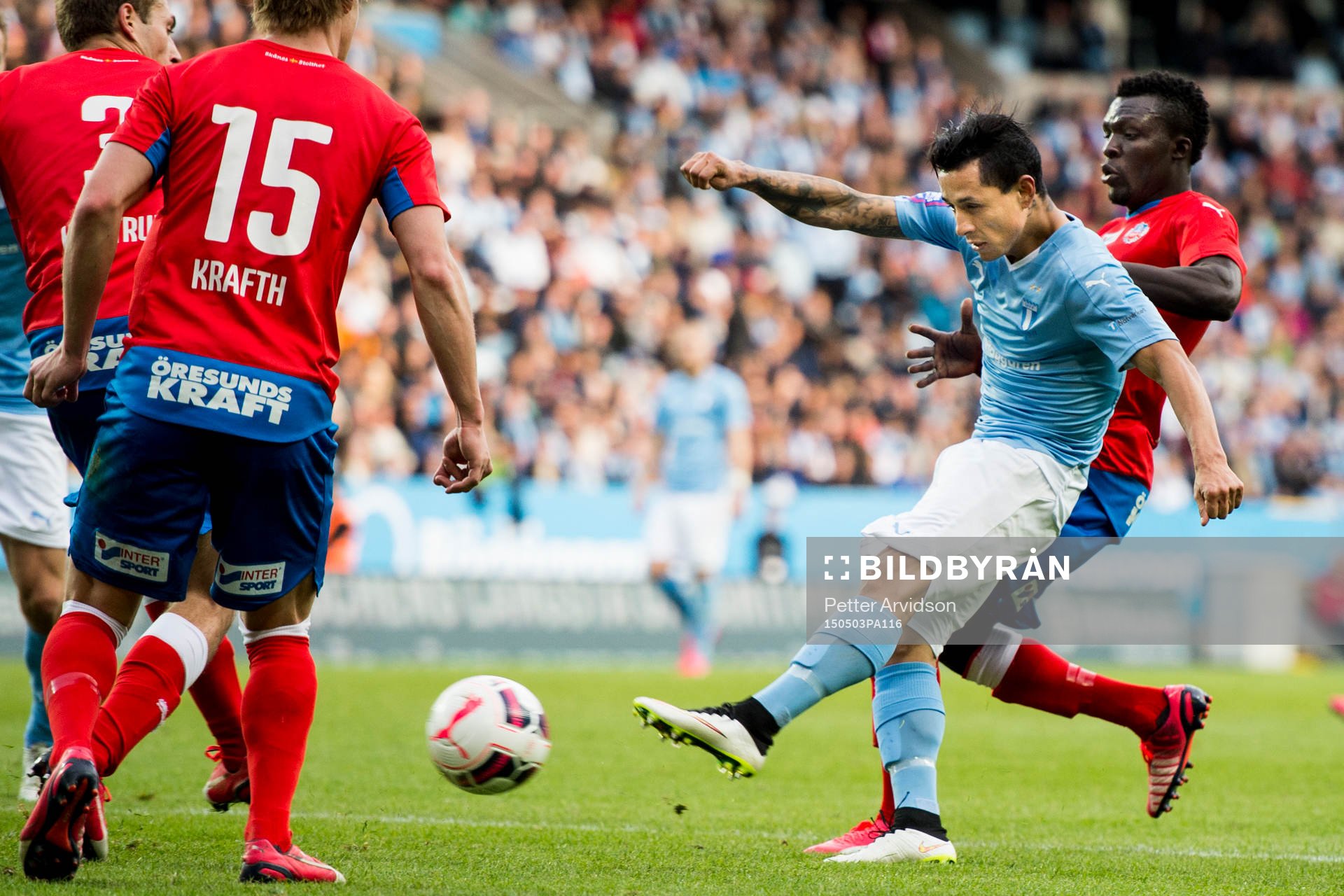 Malmö FFs Victor Yoshimar Yotun Flores skjuter i kamp med Helsingborgs Lalawélé Atakora under fotbollsmatchen i Allsvenskan mellan Malmö FF och Helsingborg den 3 maj 2015 i Malmö.