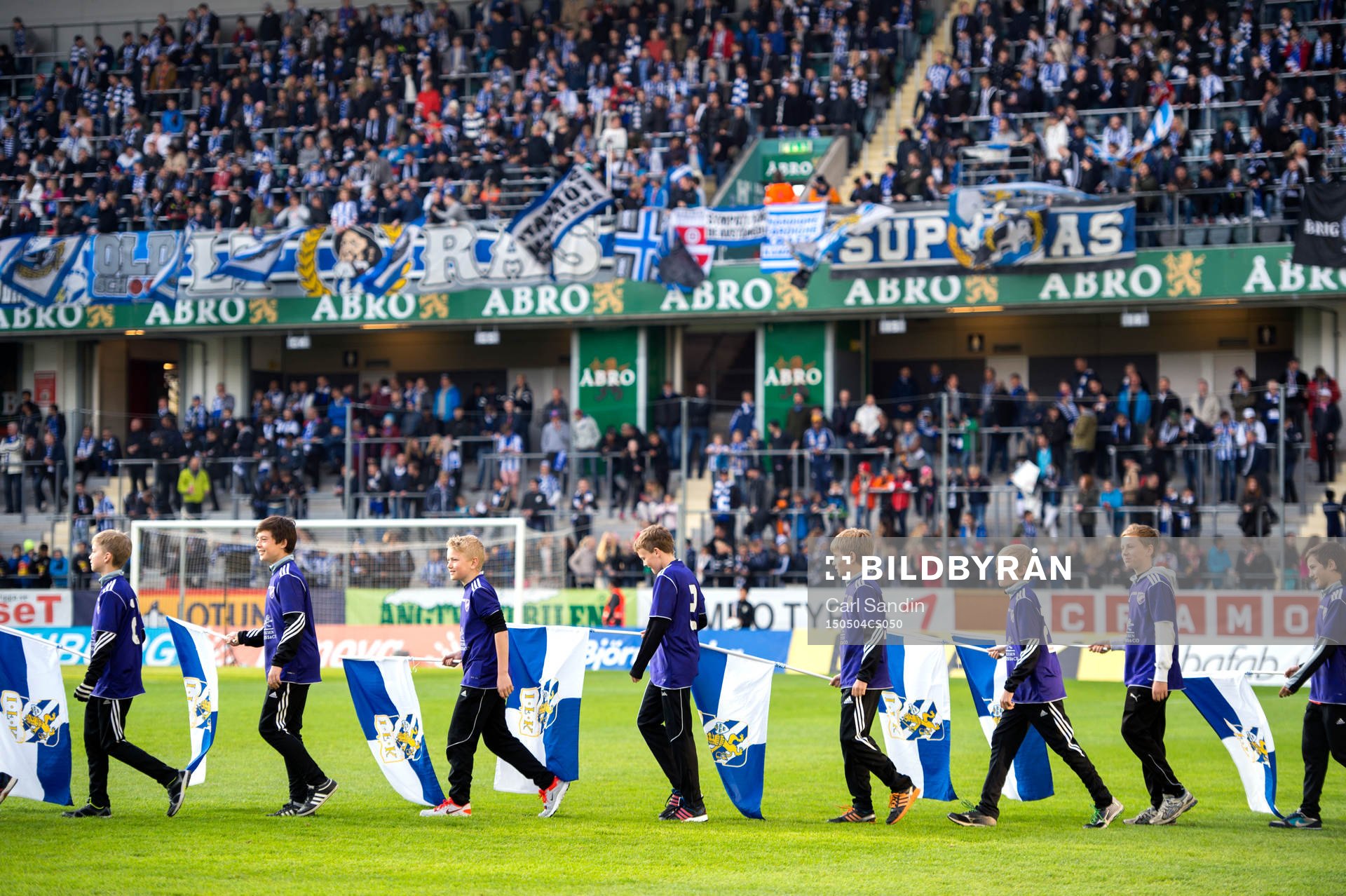 Flaggbärare gå in på planen innan en fotbollsmatch i