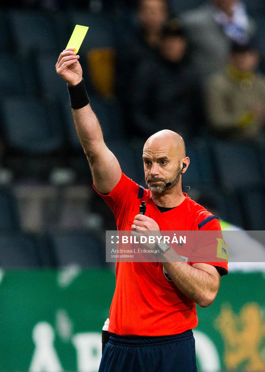 Domare Stefan Johannesson visar ett gult kort
