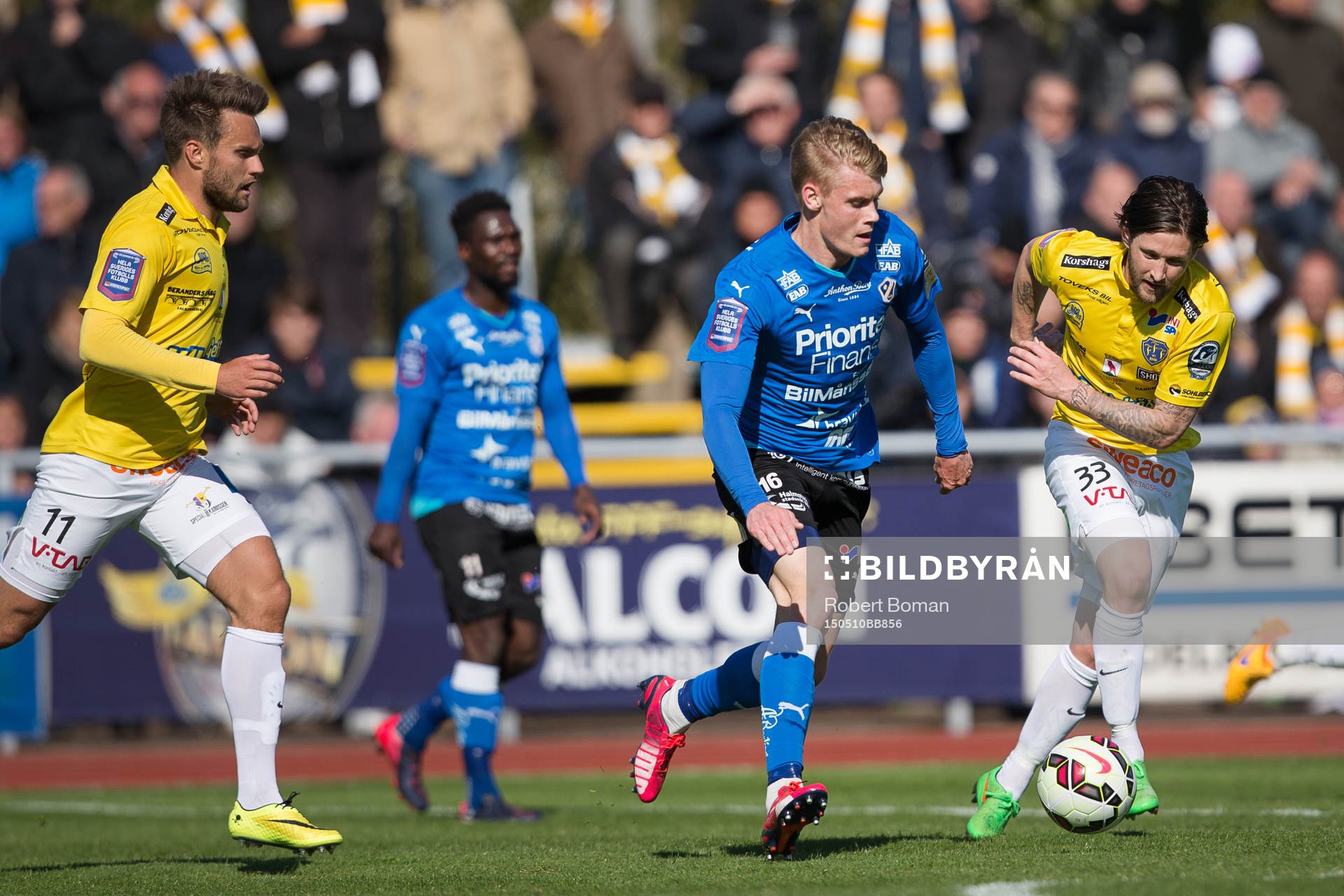 Falkenbergs Johannes Vall (till vänster) och Halmstads King Osei Gyan (i bakgrunden) och Halmstads Erik Smith (med bollen) och Falkenbergs Tibor Joza (till höger) under fotbollsmatchen i Allsvenskan mellan Falkenbergs FF och Halmstads BK den 10 maj 2015 i Falkenberg.