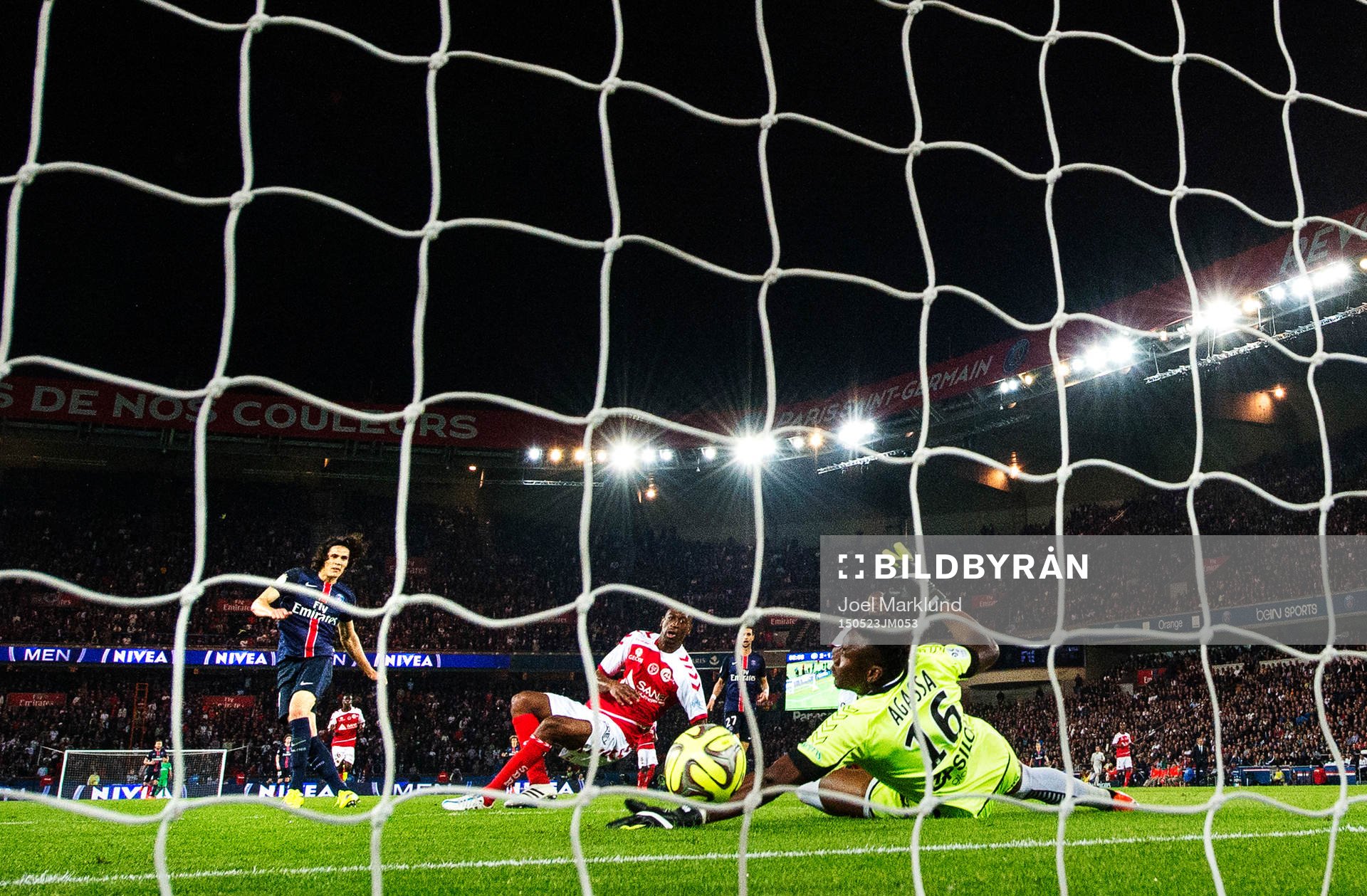 s Edinson Cavani skjuter in 3-1 bakom Reims målvakt Kossi