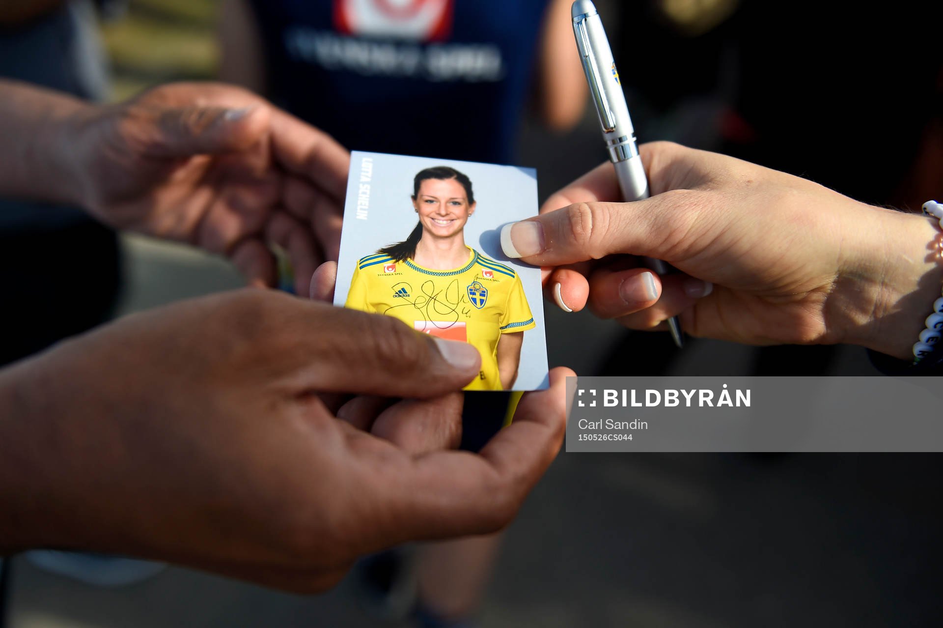 Sveriges Lotta Schelin delar ut signerade kort efter en träning med landslaget den 26 maj 2015 i Toronto.