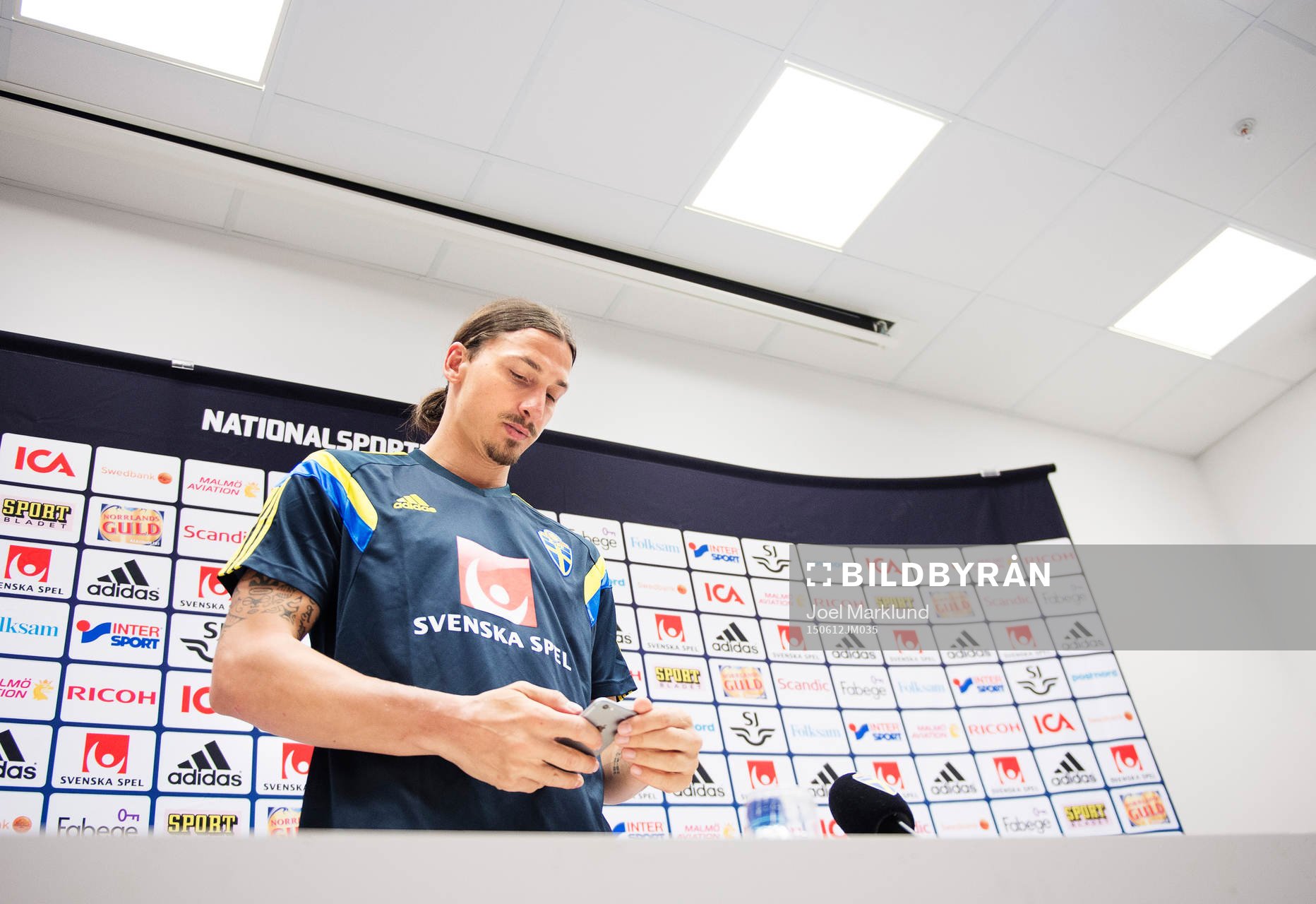 Zlatan Ibrahimovic kollar på sin mobiltelefon på en