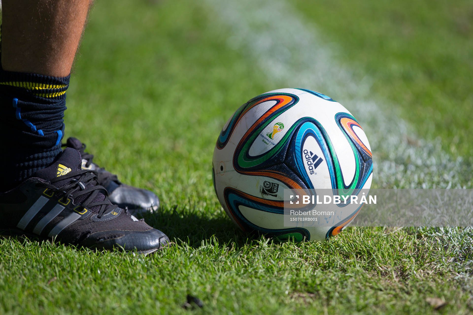 En fotboll ligger framför en spelares fötter under Svenska fotbollsförbundets elitläger i Halmstad den 3 Juli 2015 i Halmstad.