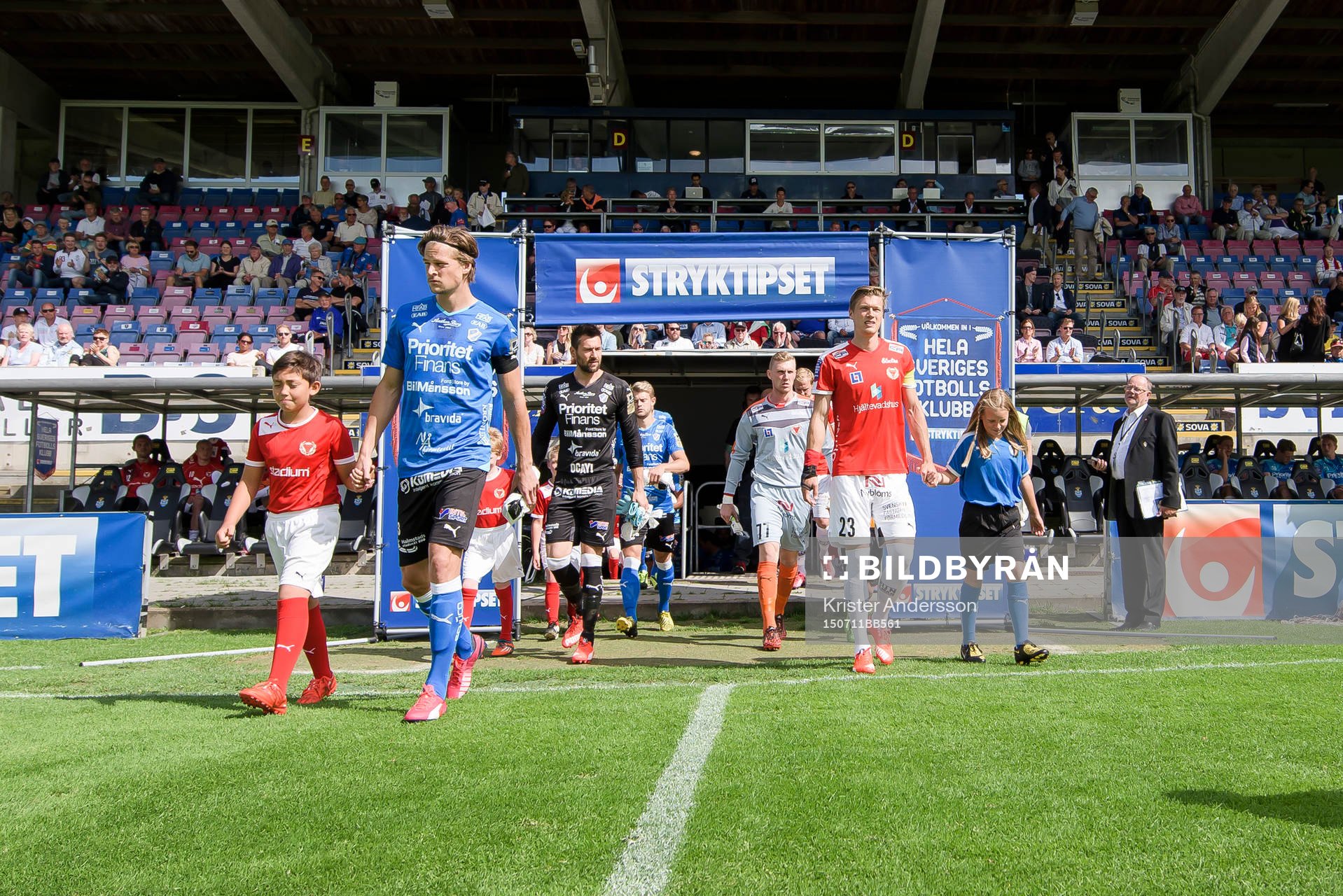 Spelarna kommer in på planen före fotbollsmatchen i