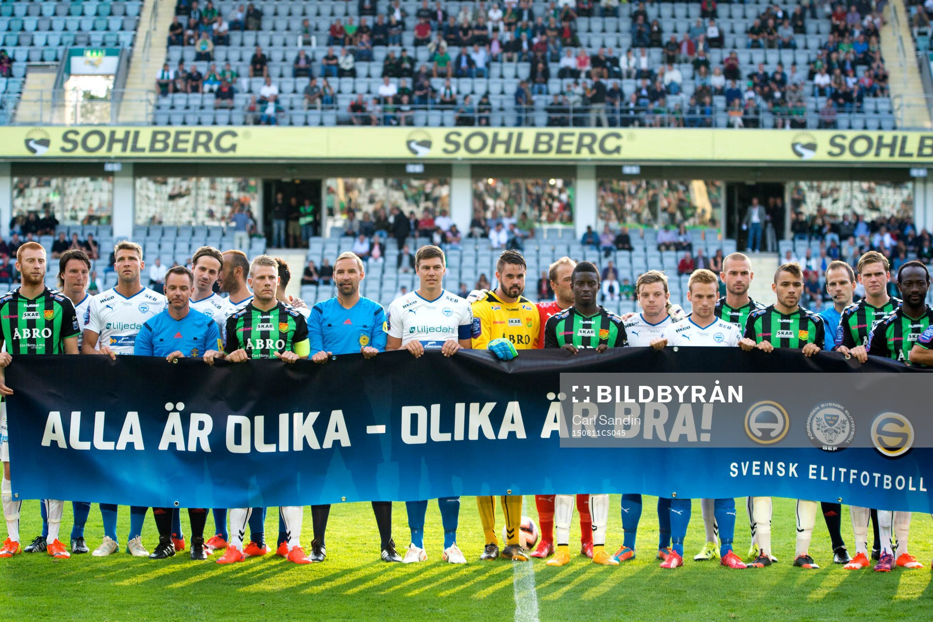 Spelarna håller upp en banderoll med texten Alla är