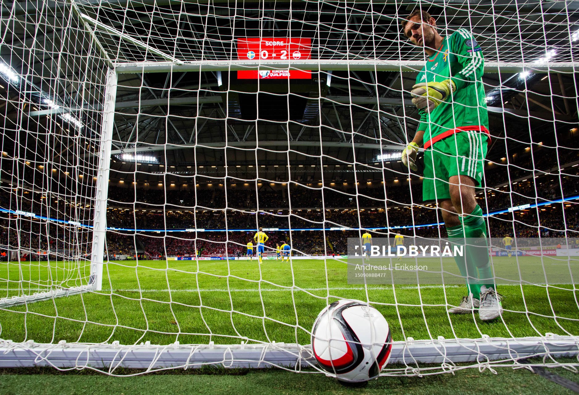 Sveriges målvakt Andreas Isaksson plockar ut bollen ur mål