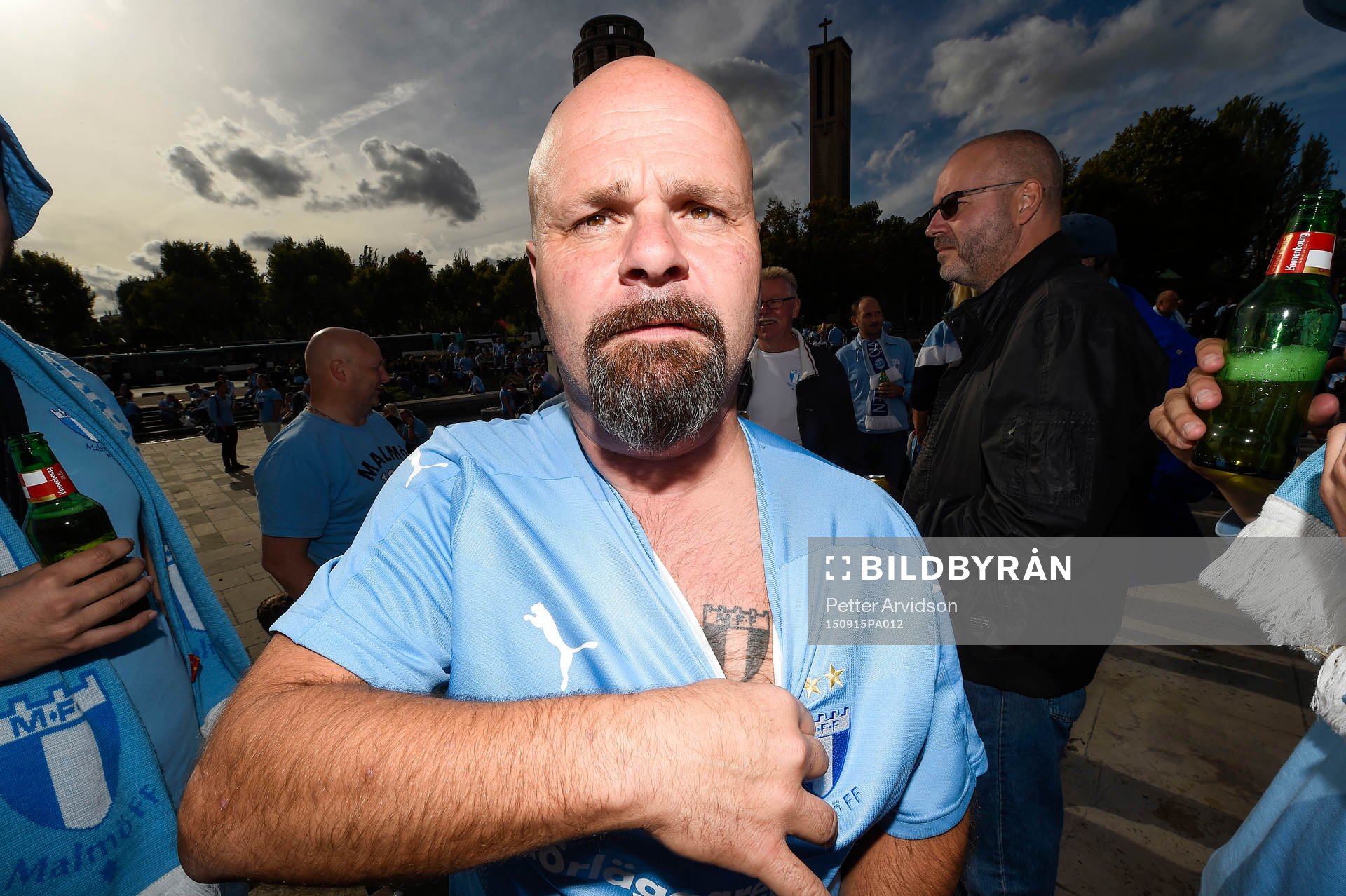 En man visar upp sin tatuering när supportrar till Malmö