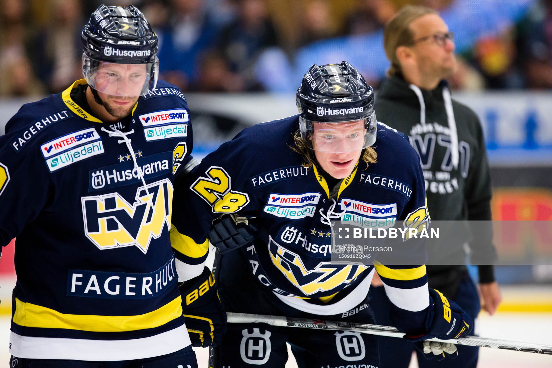 s Anton Bengtsson (i) leds av isen av HV71:s Chris Abbott