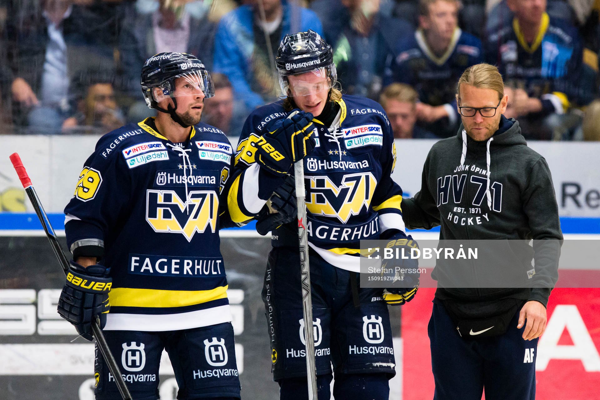 s Anton Bengtsson (i) leds av isen av HV71:s Chris Abbott