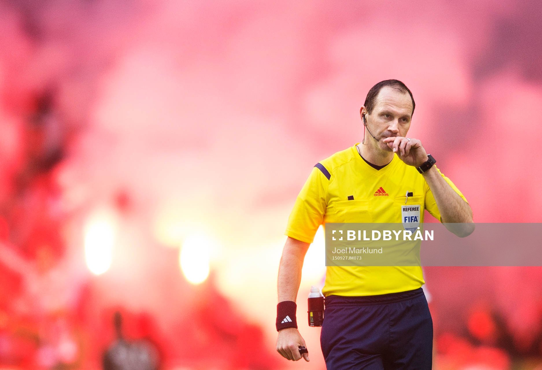 Domare Jonas Eriksson med bengaleldar bakom sig under fotbollsmatchen i Allsvenskan mellan Hammarby och AIK den 27 september 2015 i Stockholm.