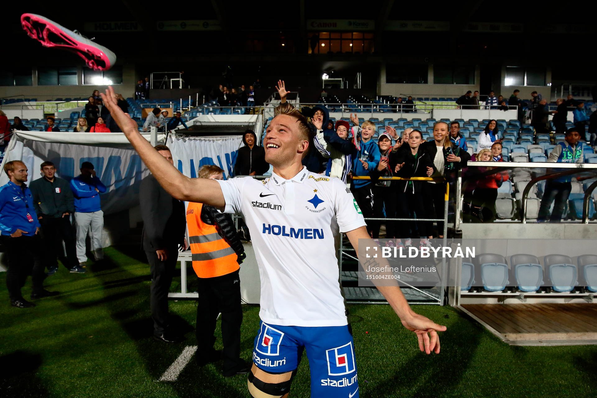 Norrköpings Nicklas Bärkroth kastar fotbollsko till barnen