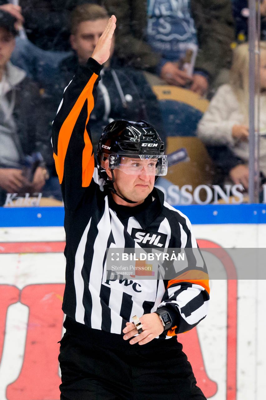 Domaren Christoffer Karlsson håller upp armen för en