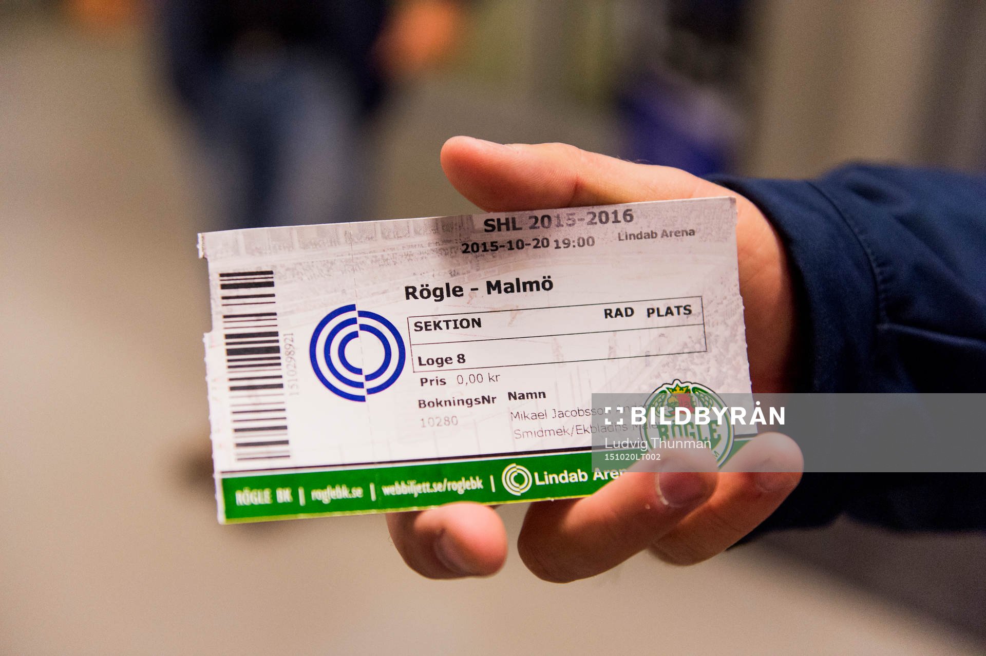 En besökare håller upp matchbiljetten