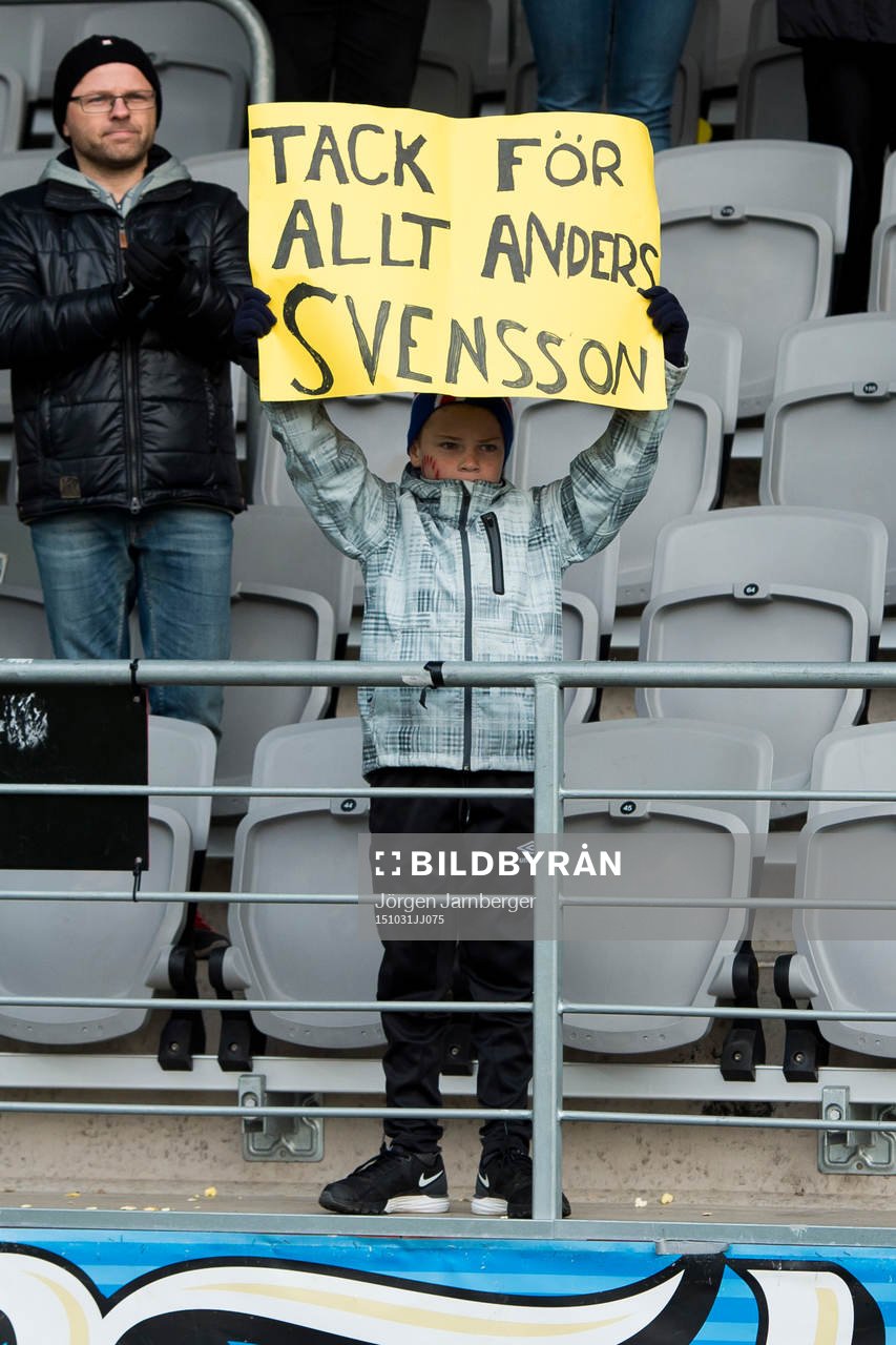 En liten kille i publiken håller upp en skyllt med texten