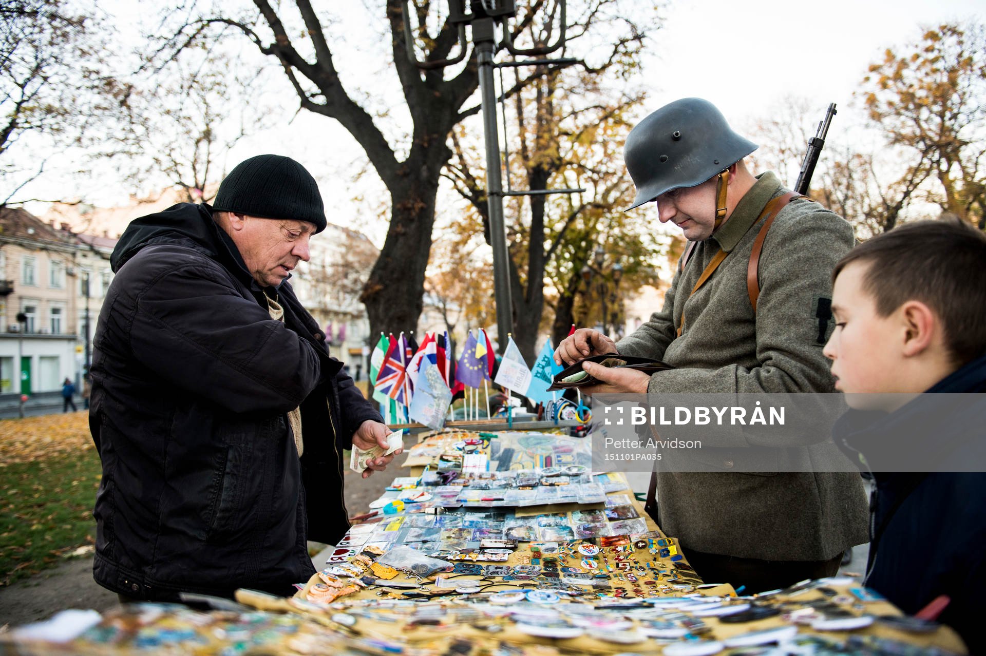 En beväpnad militär köper pins på en marknad en