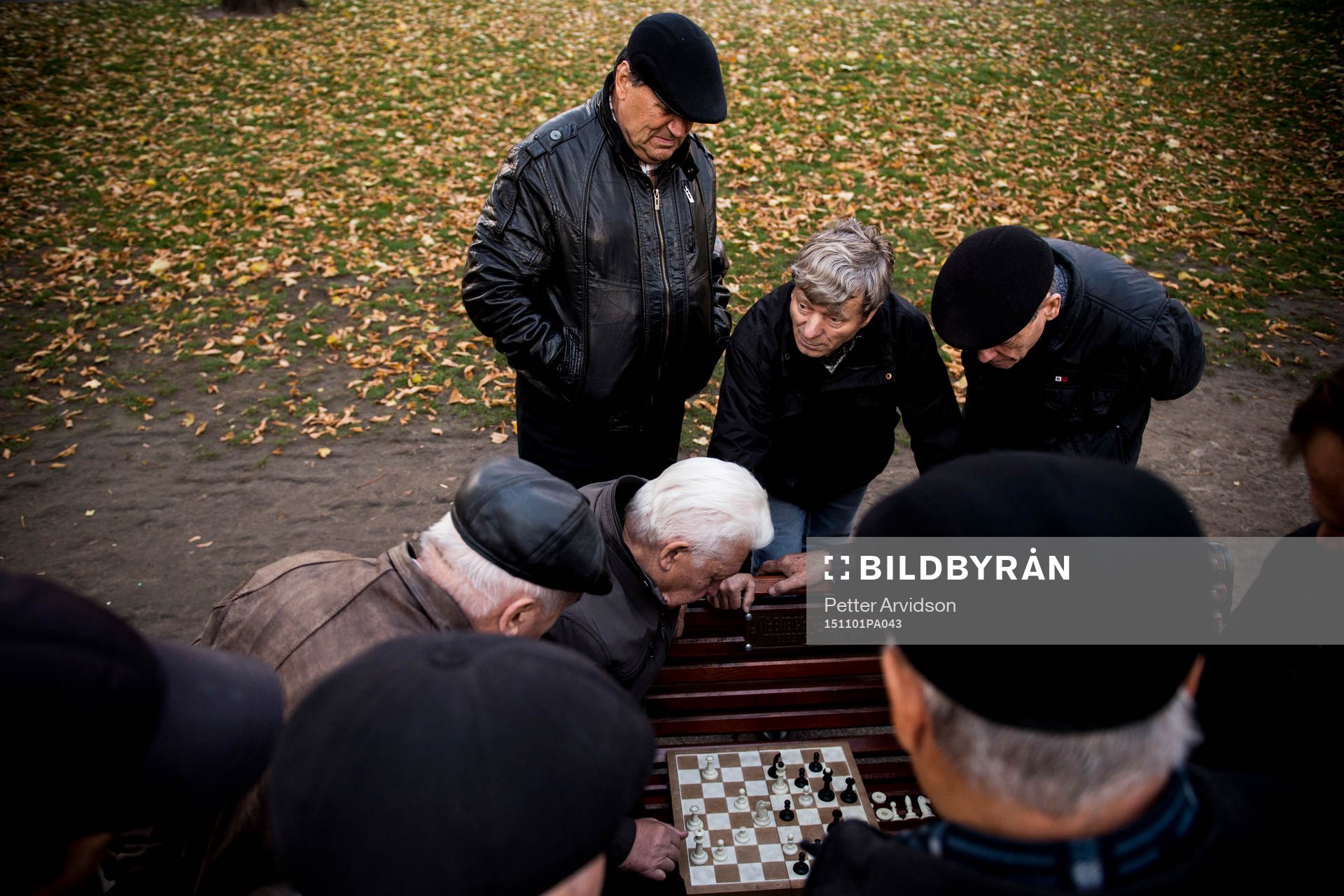 Äldre herrar spelar schack på en parkbänk en