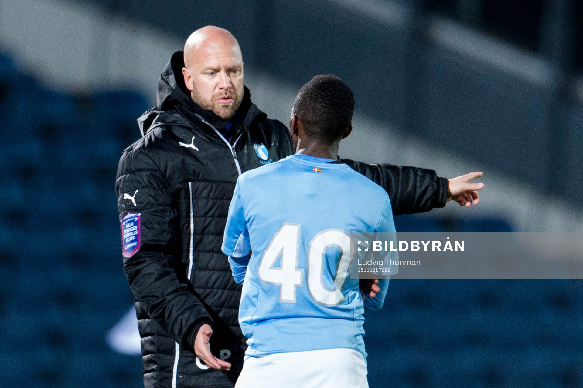 Malmös assisterande tränare Olof Persson i samtal med Malmös Lumala Abdu under träningsmatchen i fotboll mellan Malmö FF och Sverige U21 den 12 november 2015 i Malmö.