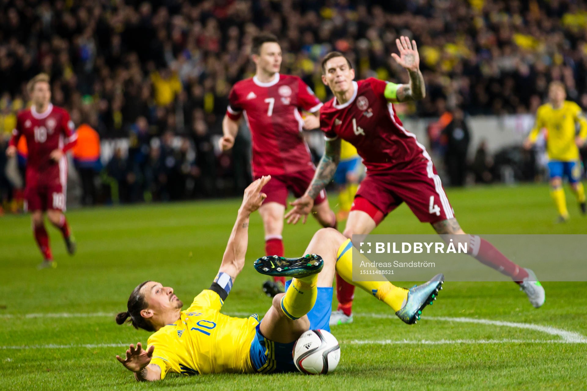 Sveriges Zlatan Ibrahimovic faller i en duell med Danmarks Daniel Agger under fotbollsmatchen i EM-kvalets playoff mellan Sverige och Danmark den 14 November 2015 i Stockholm.