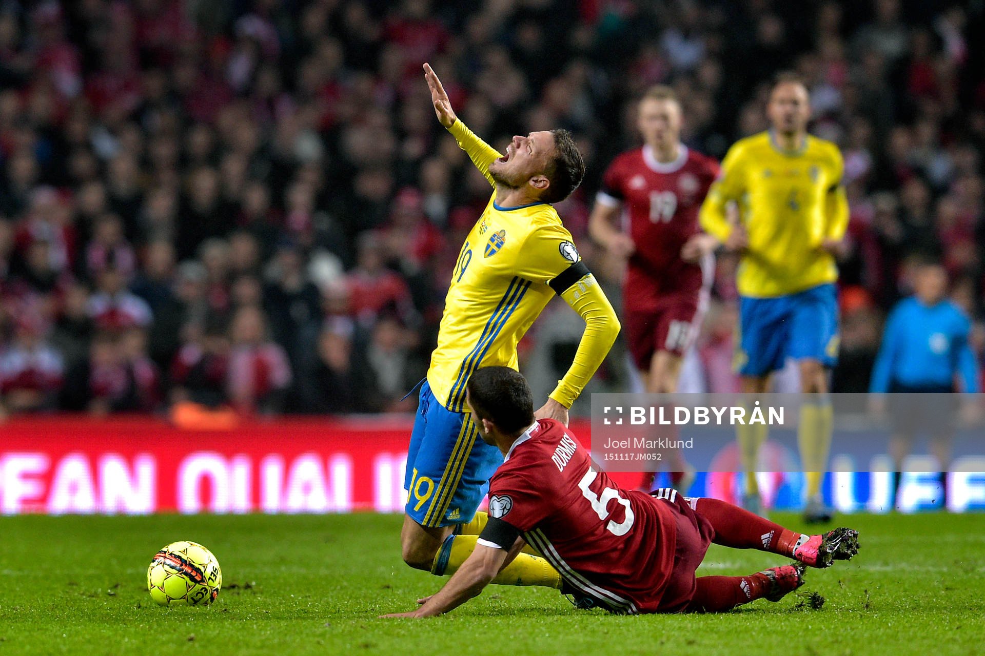 Sveriges Marcus Berg blir fälld av Danmarks Riza Durmisi under fotbollsmatchen i EM-kvalets playoff mellan Danmark och Sverige den 17 november 2015 i Köpenhamn.
