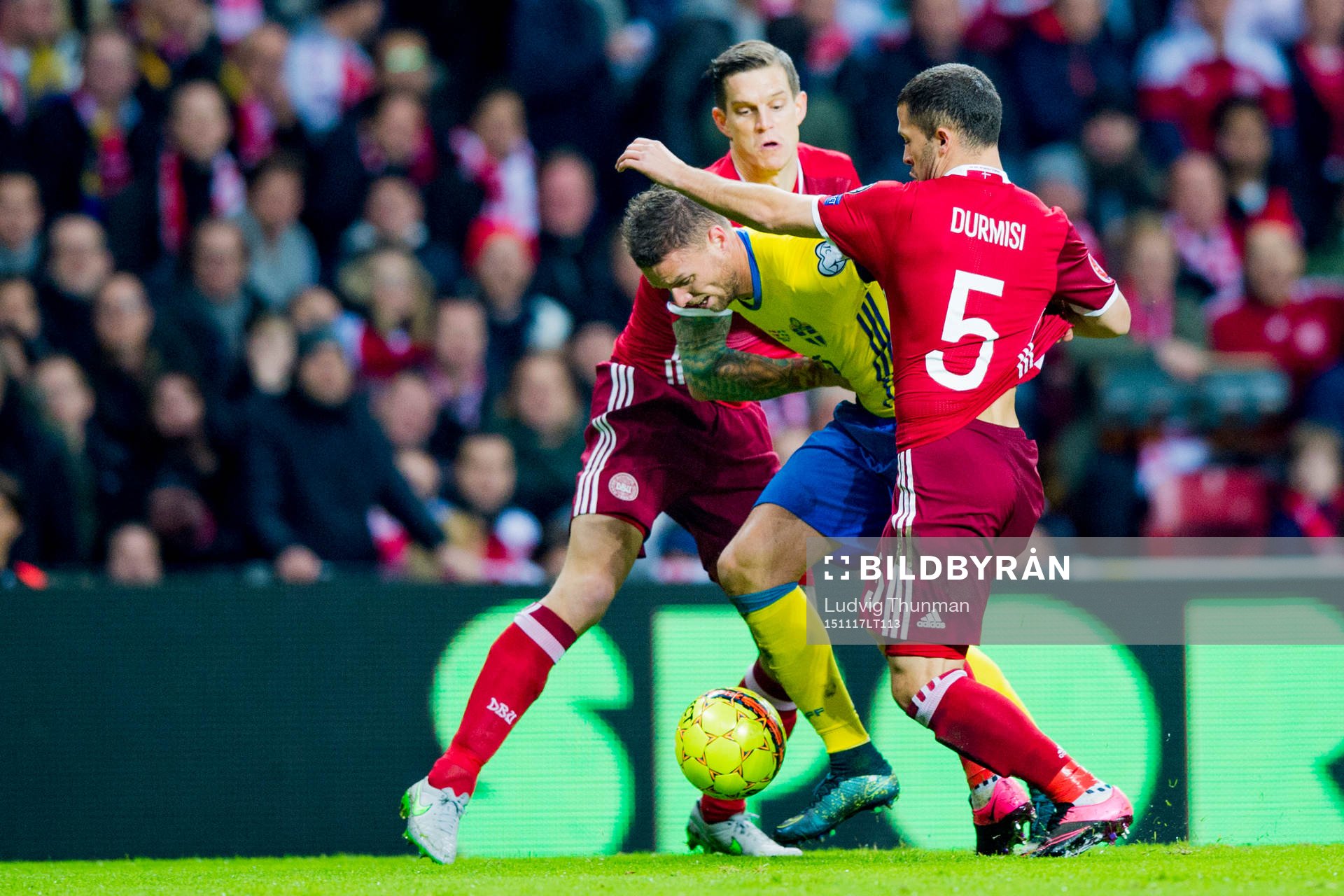 Danmarks Daniel Agger och Riza Durmisi försöker stoppa Sveriges Marcus Berg under fotbollsmatchen i EM-kvalets playoff mellan Danmark och Sverige den 17 november 2015 i Köpenhamn.