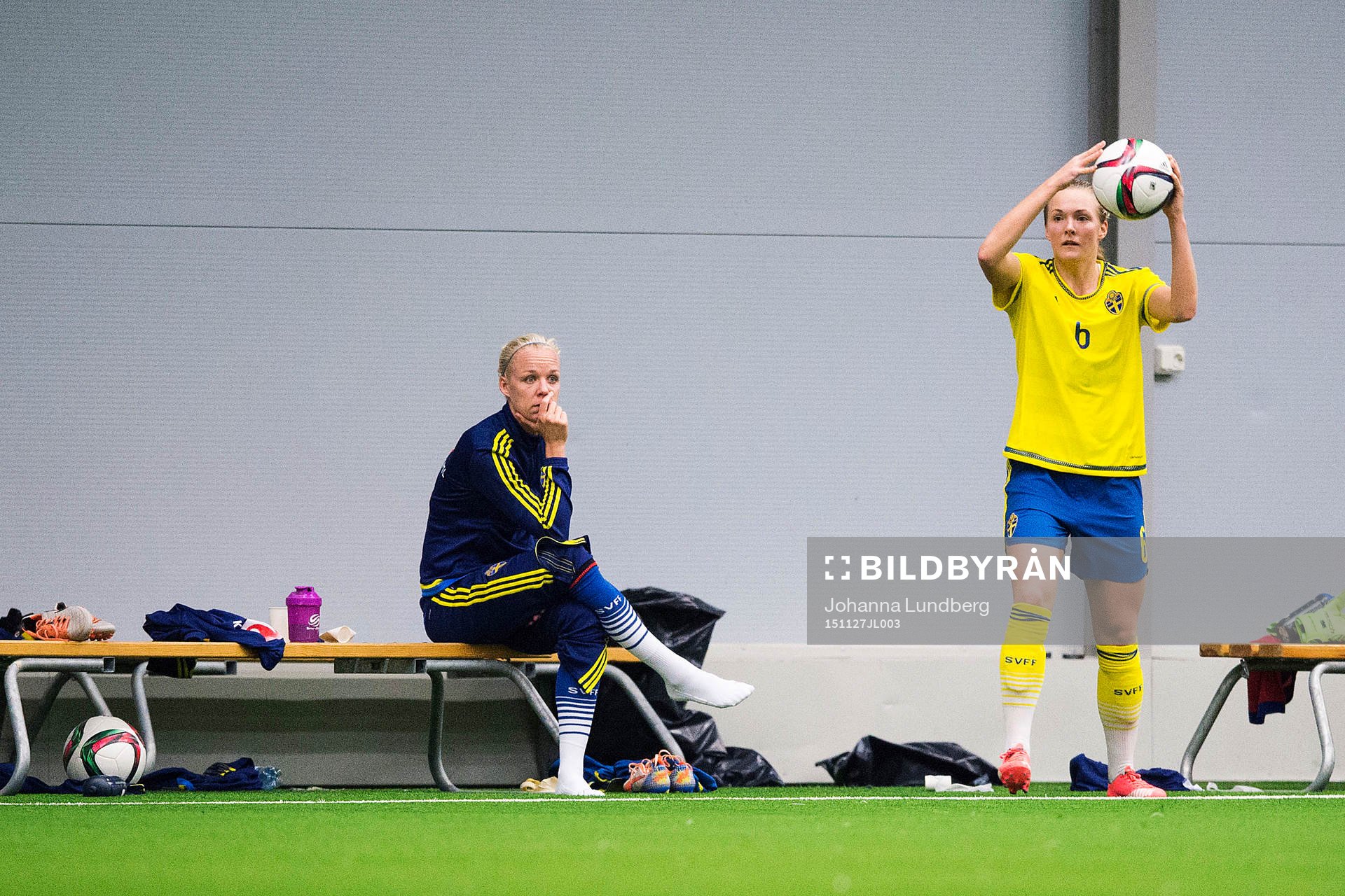 Caroline Seger på bänken ser hur Magdalena Ericsson tar ett inkast under en internmatch i fotboll för det Svenska fotbollslandslaget den 27 november 2015 i Stockholm.