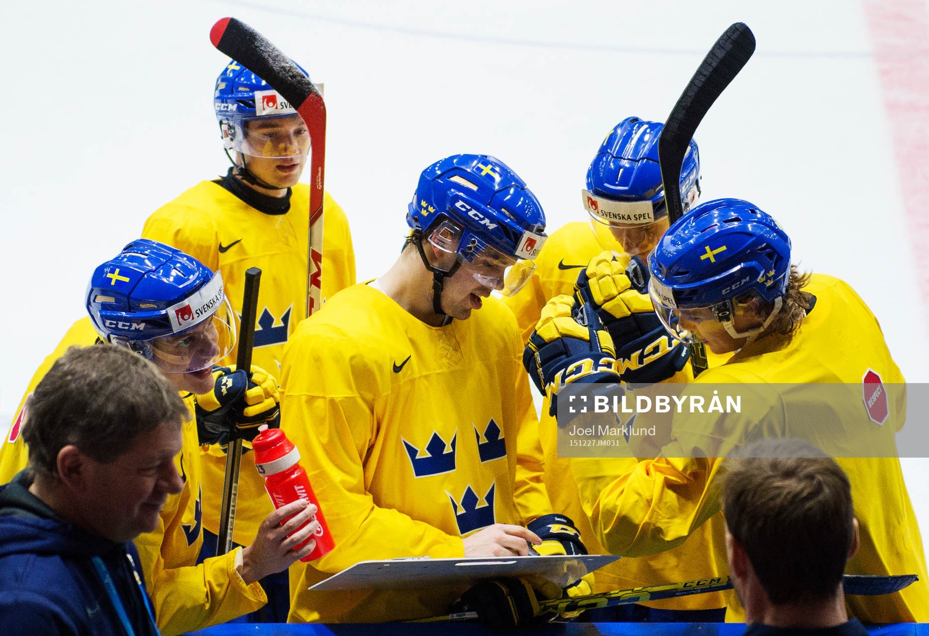 Axel Holmström (mitten) ritar på en taktiktavla