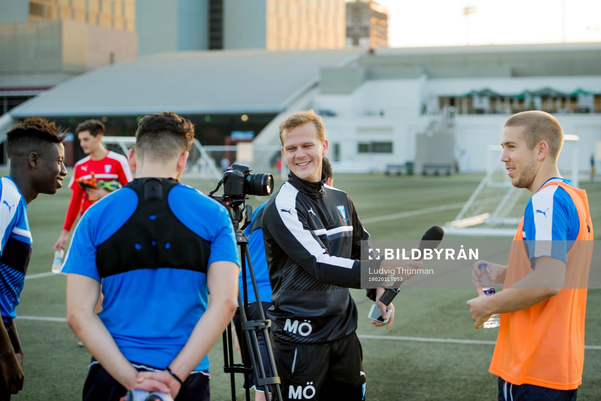 Malmö FFs Pa Konate, Erdal Rakip tittar på när kommunikatör Martin Östling intervjuar Anton Tinnerholm under en träning den 1 februari 2016 i Dubai.