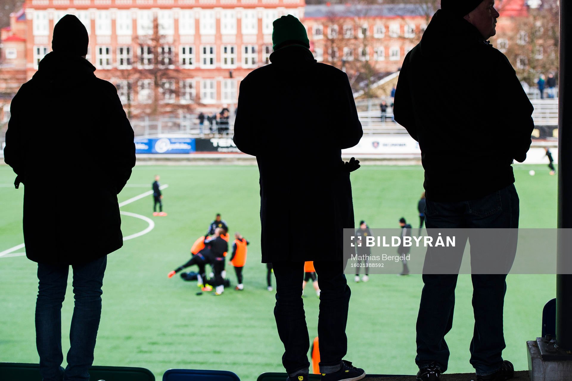 tre supportrar tittar på uppvärmningen