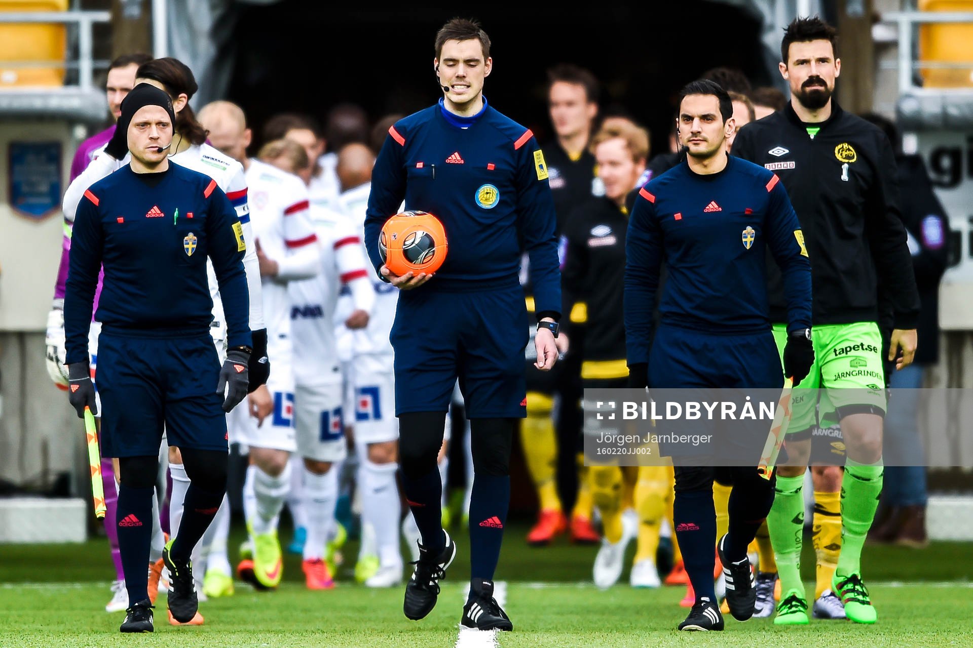 Domarna och spelarna går in på planen före  en