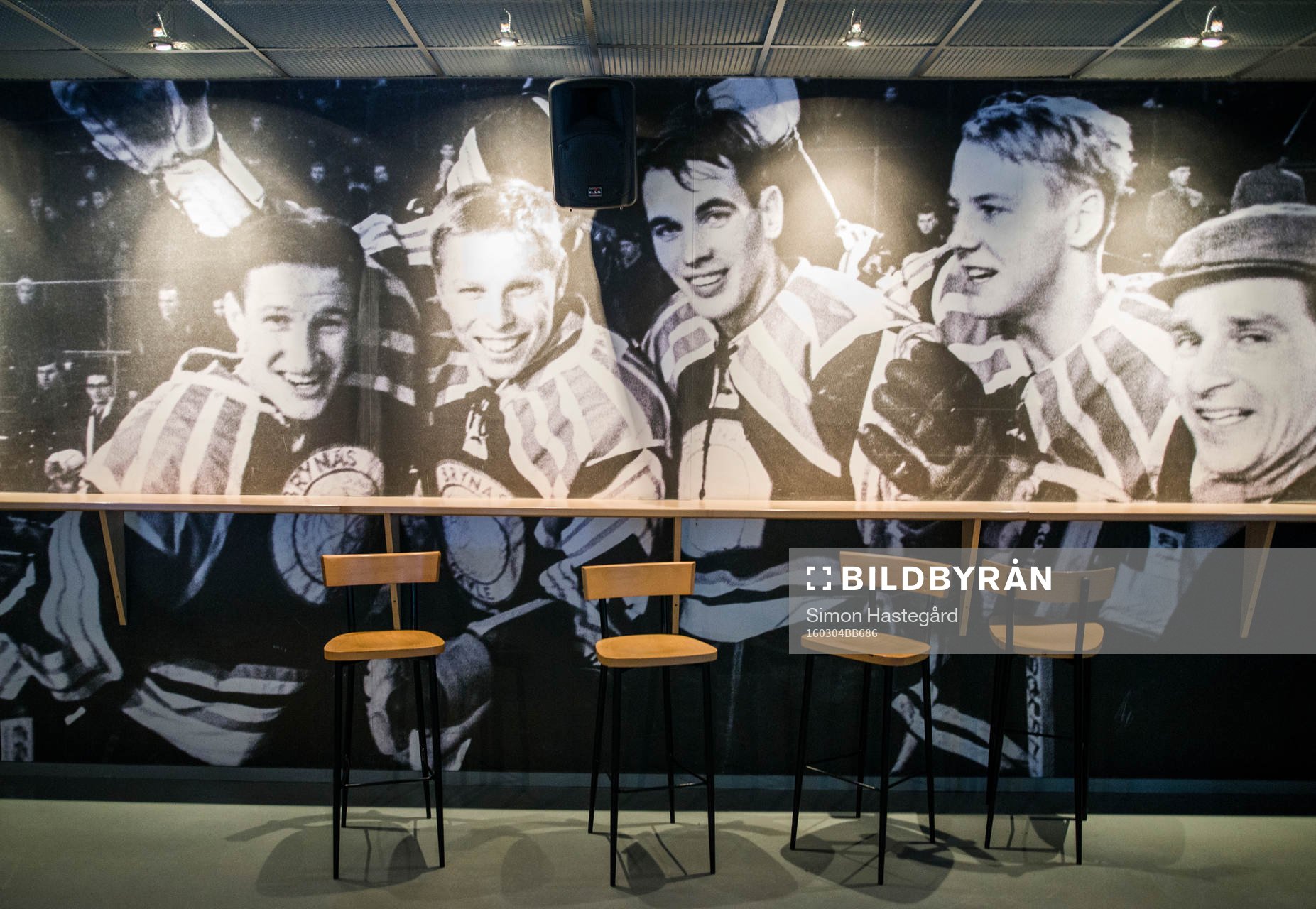 Fotovägg utav forna Brynässpelare på en barvägg inne