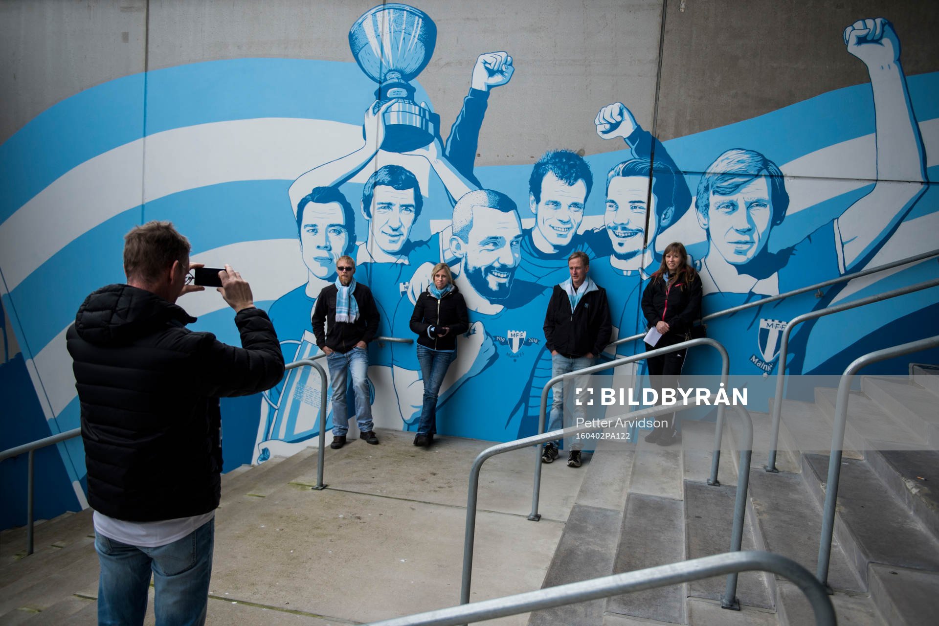 Malmö FF supportrar fotograferas framför en vägg med MFF