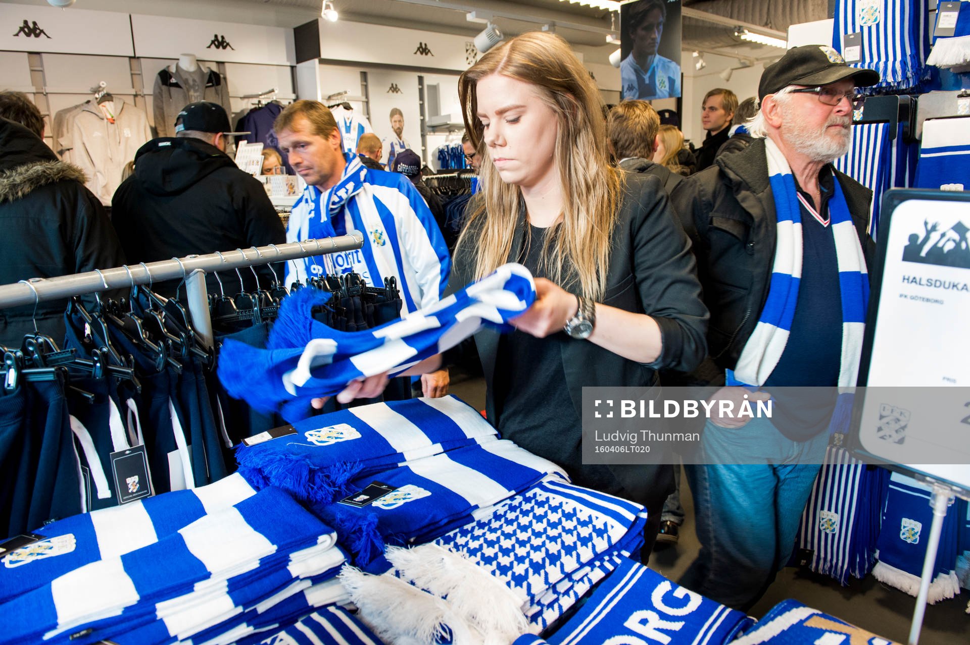 En funktionär organiserar halsdukar i shopen