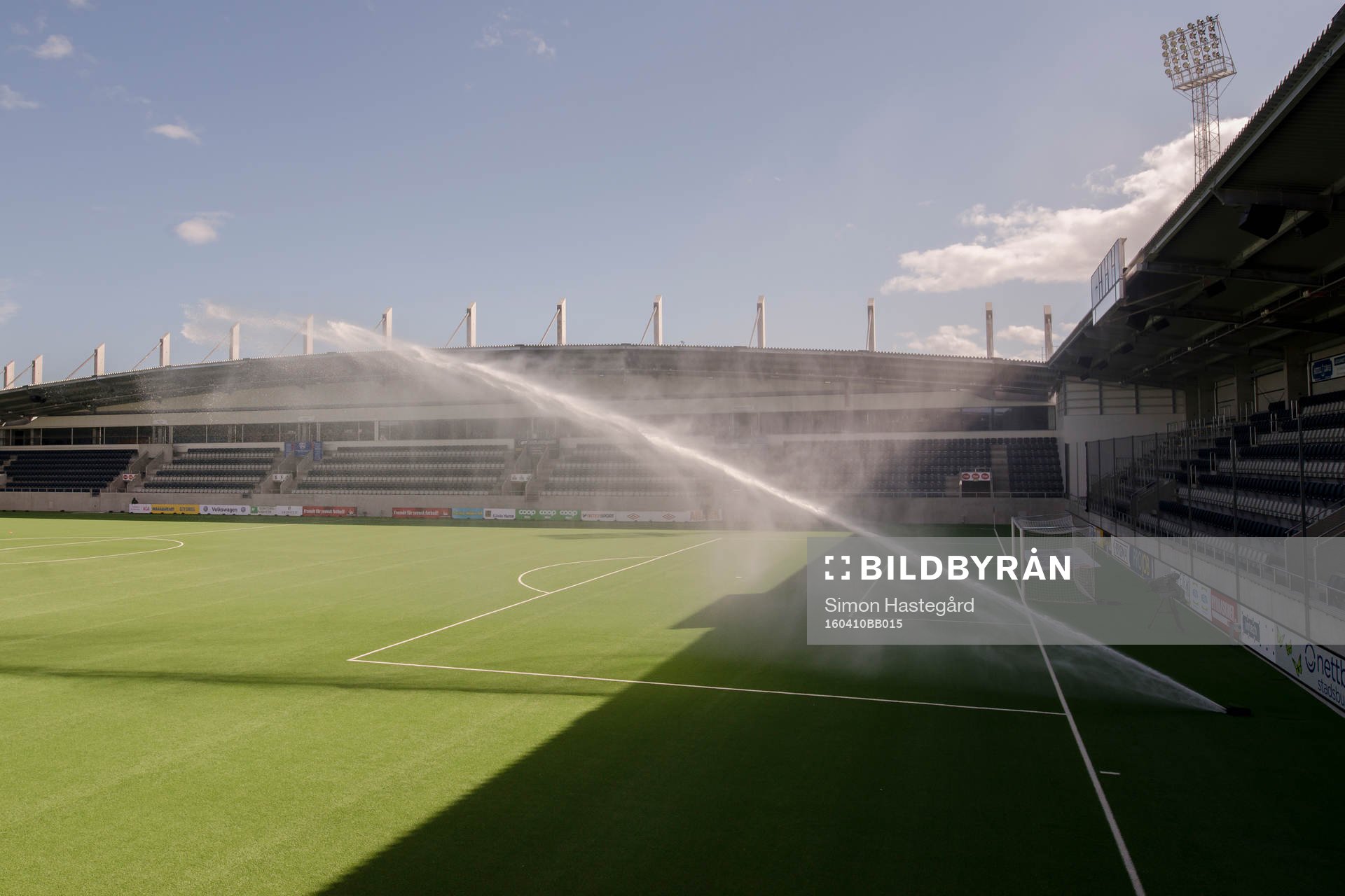 Vattenspridaren på planen före fotbollsmatchen i