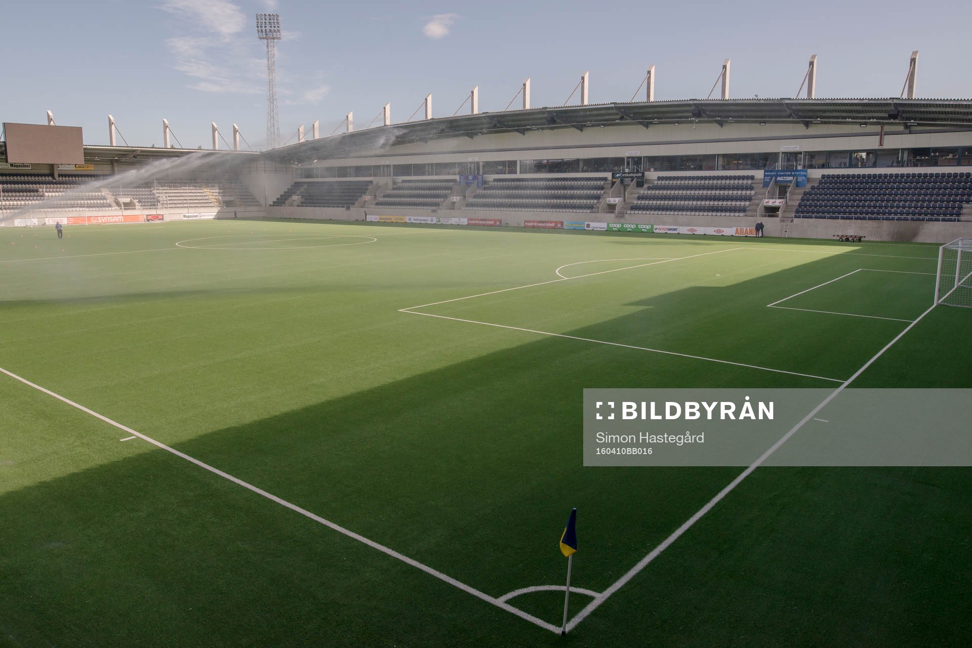 Vattenspridaren på planen före fotbollsmatchen i