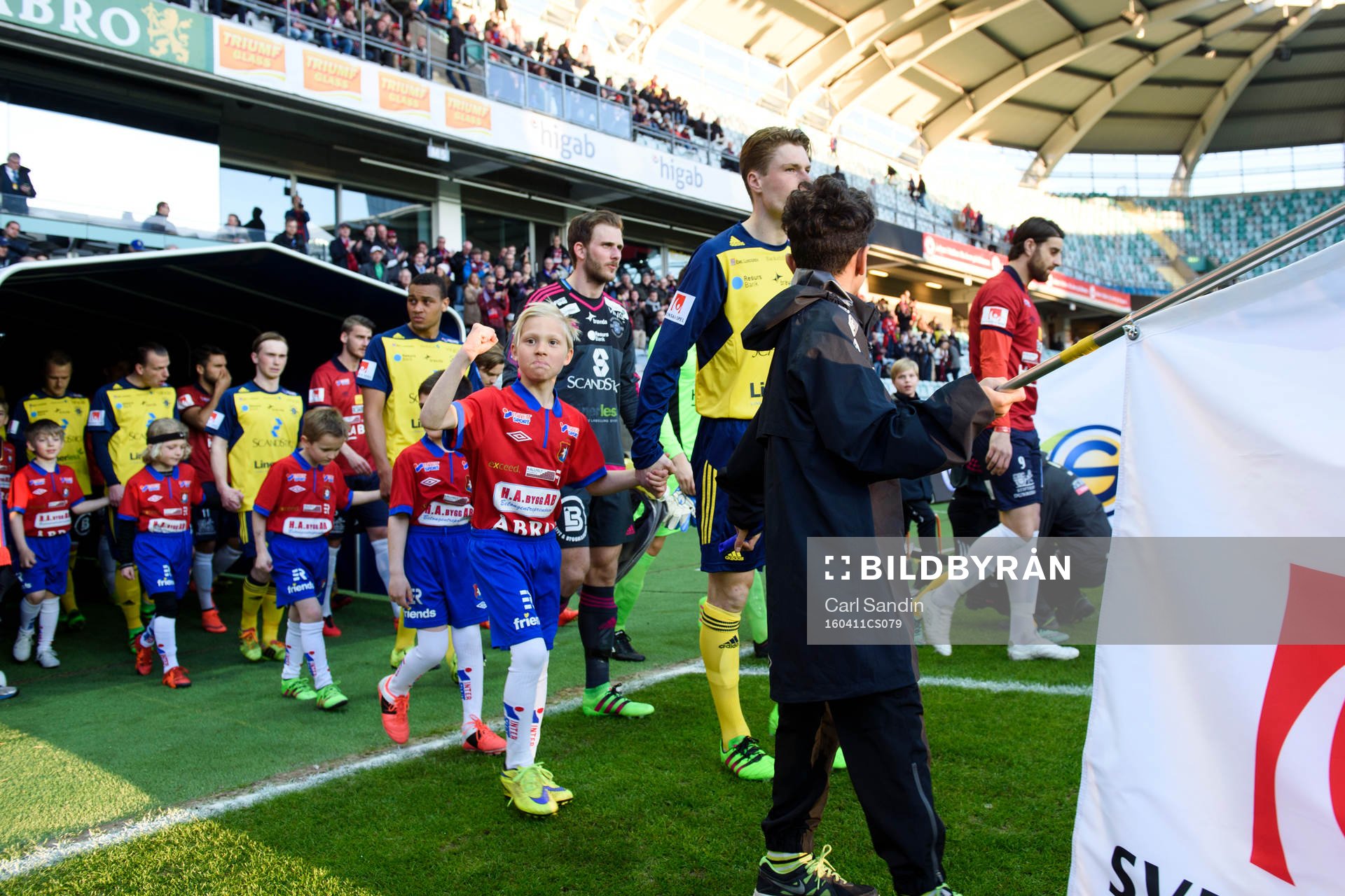 Spelarna går in på planen innan fotbollsmatchen i