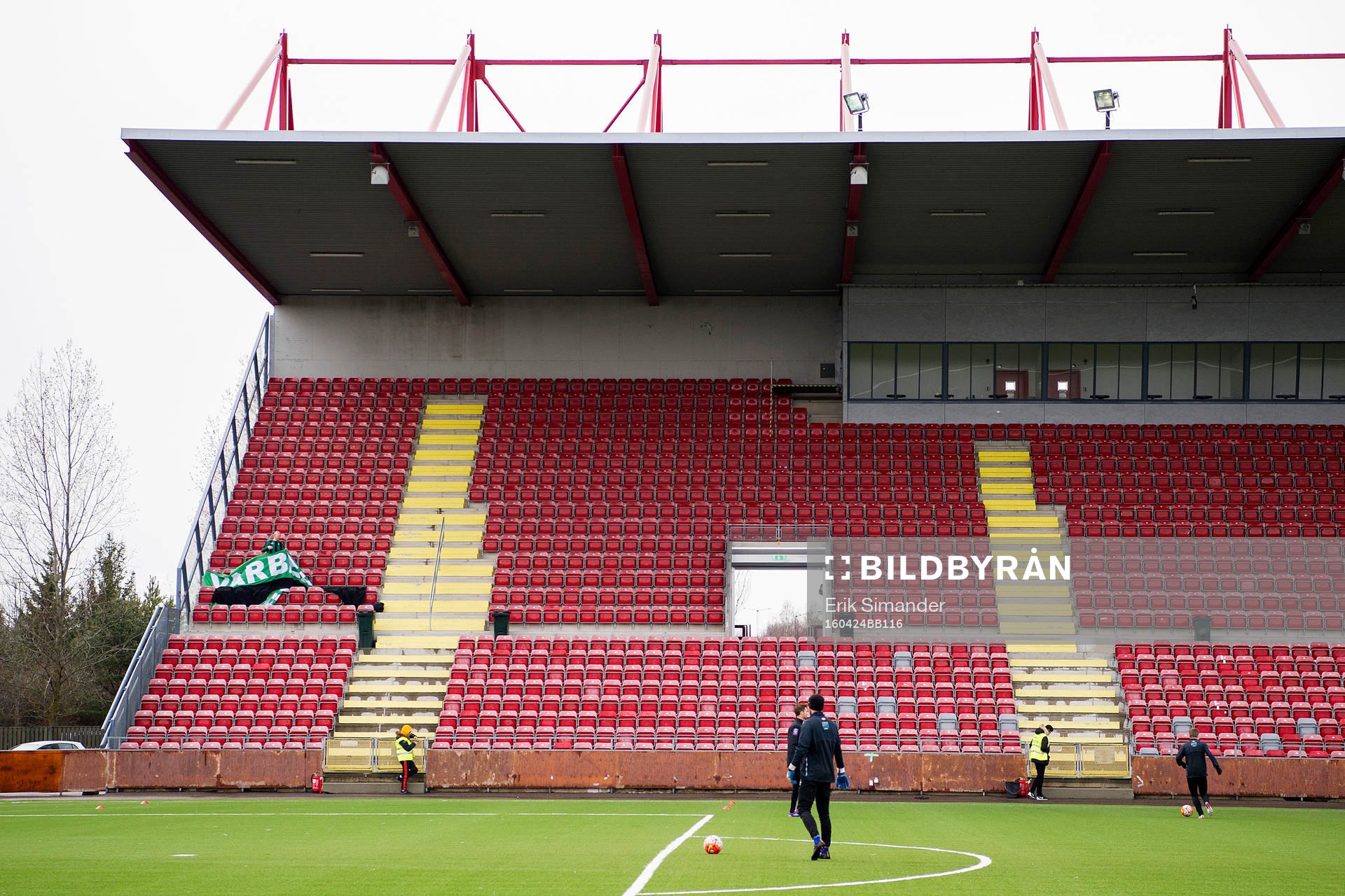 En Varbergs-supporter förbereder en banderoll på läktaren