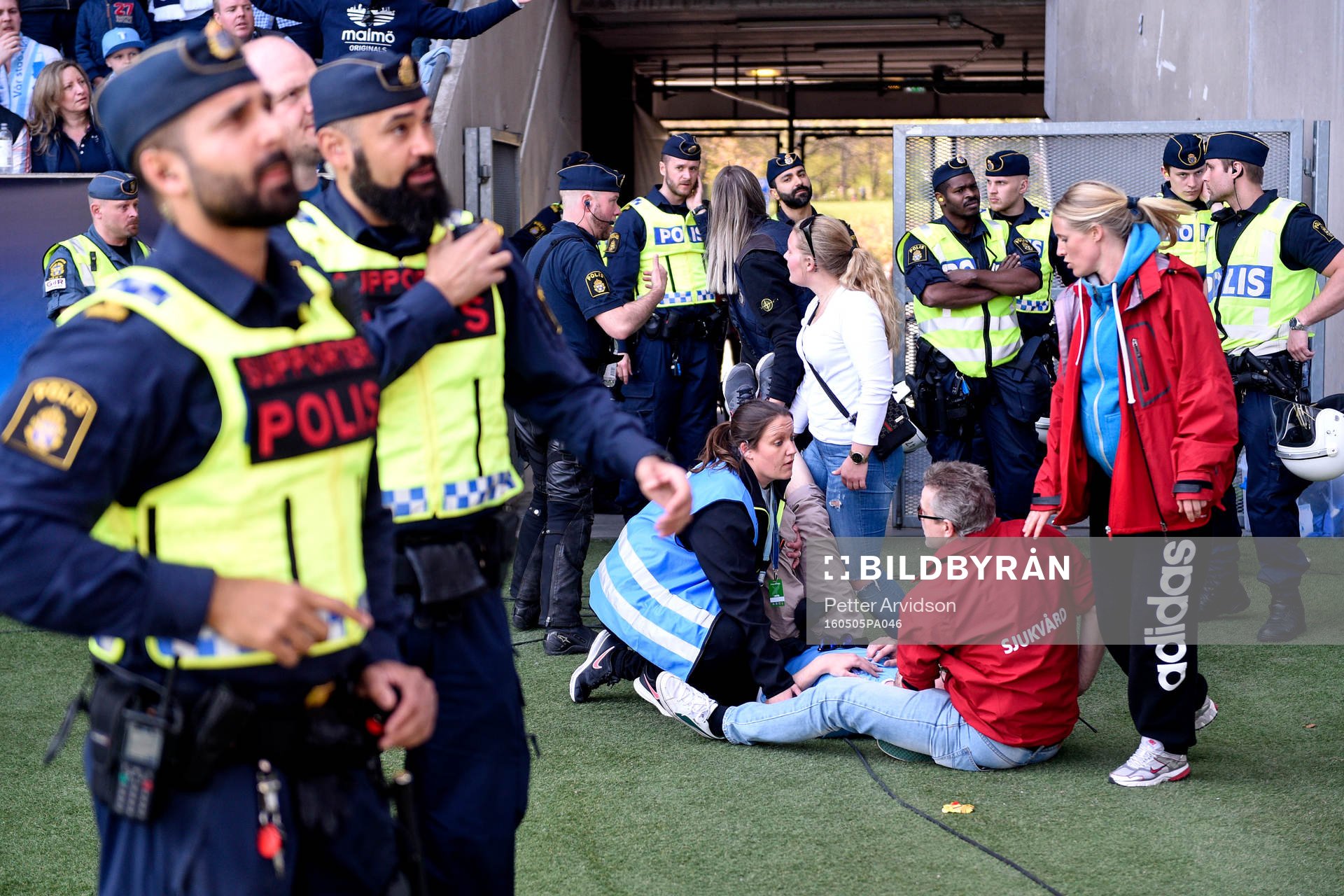 En supporter tas om hand av sjukvårdare