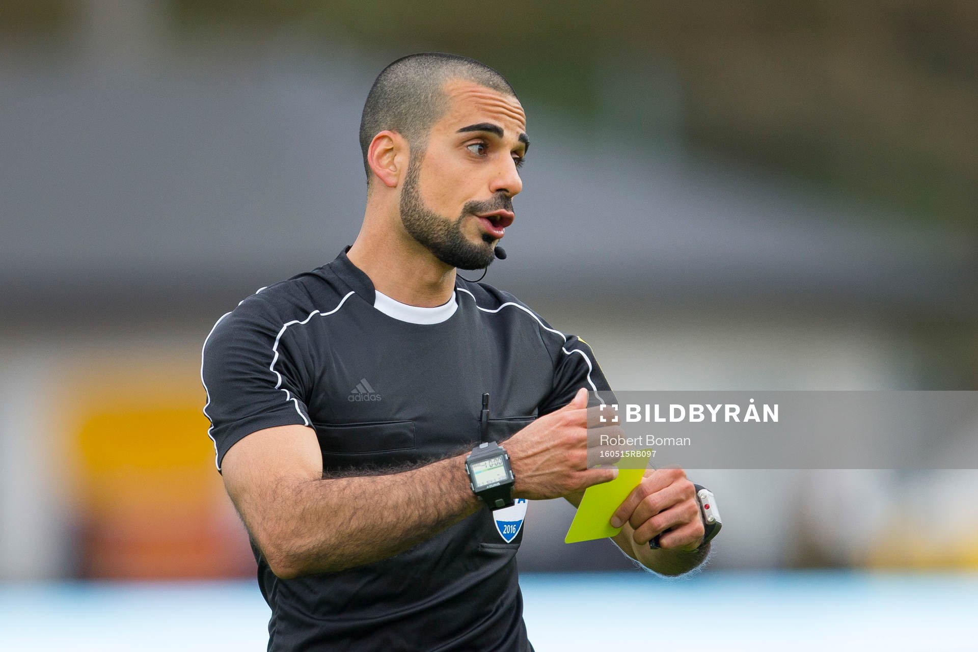 Domare Mohammed Al-Hakim ger en spelare gult kort