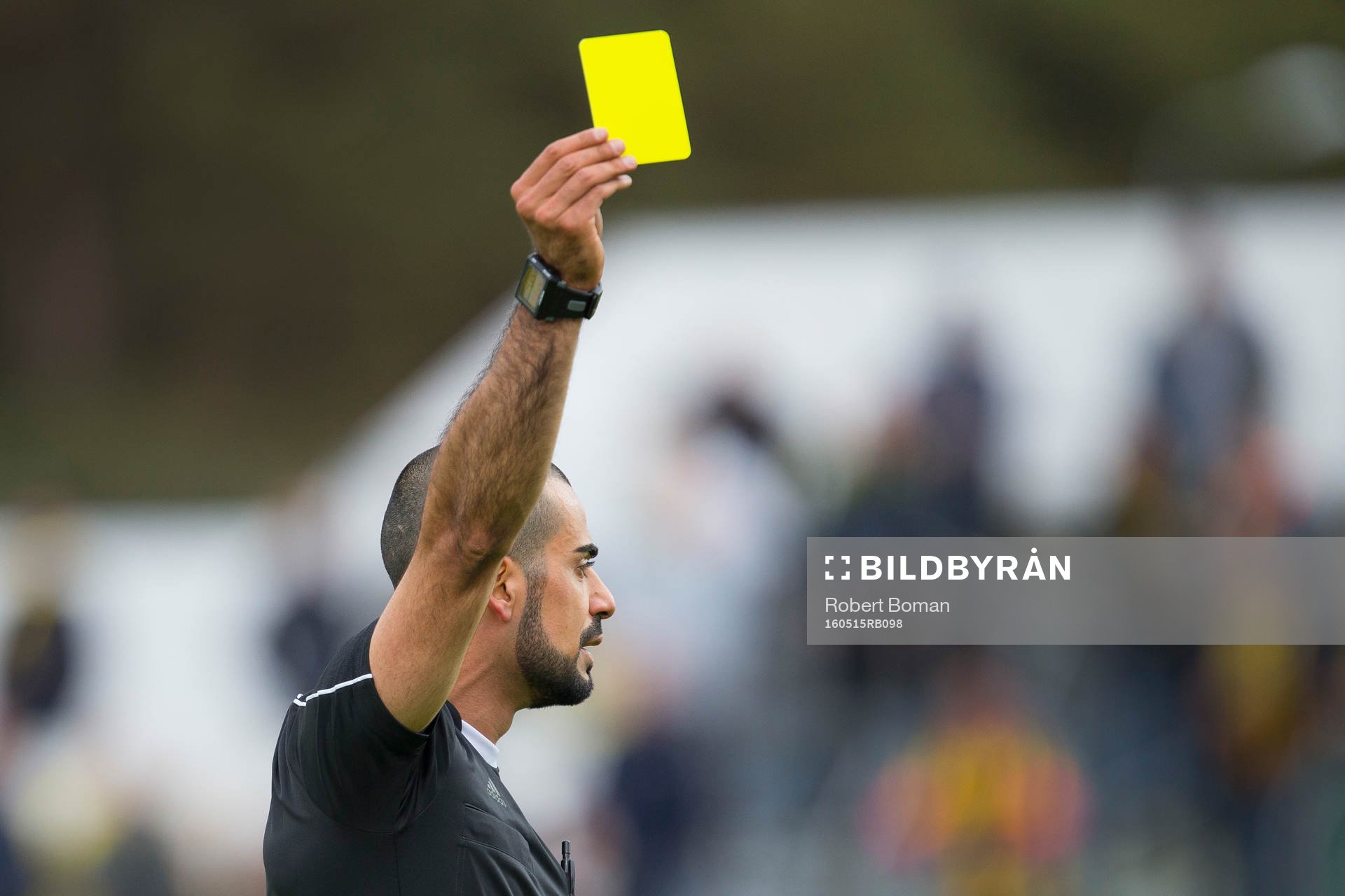 Domare Mohammed Al-Hakim ger en spelare gult kort