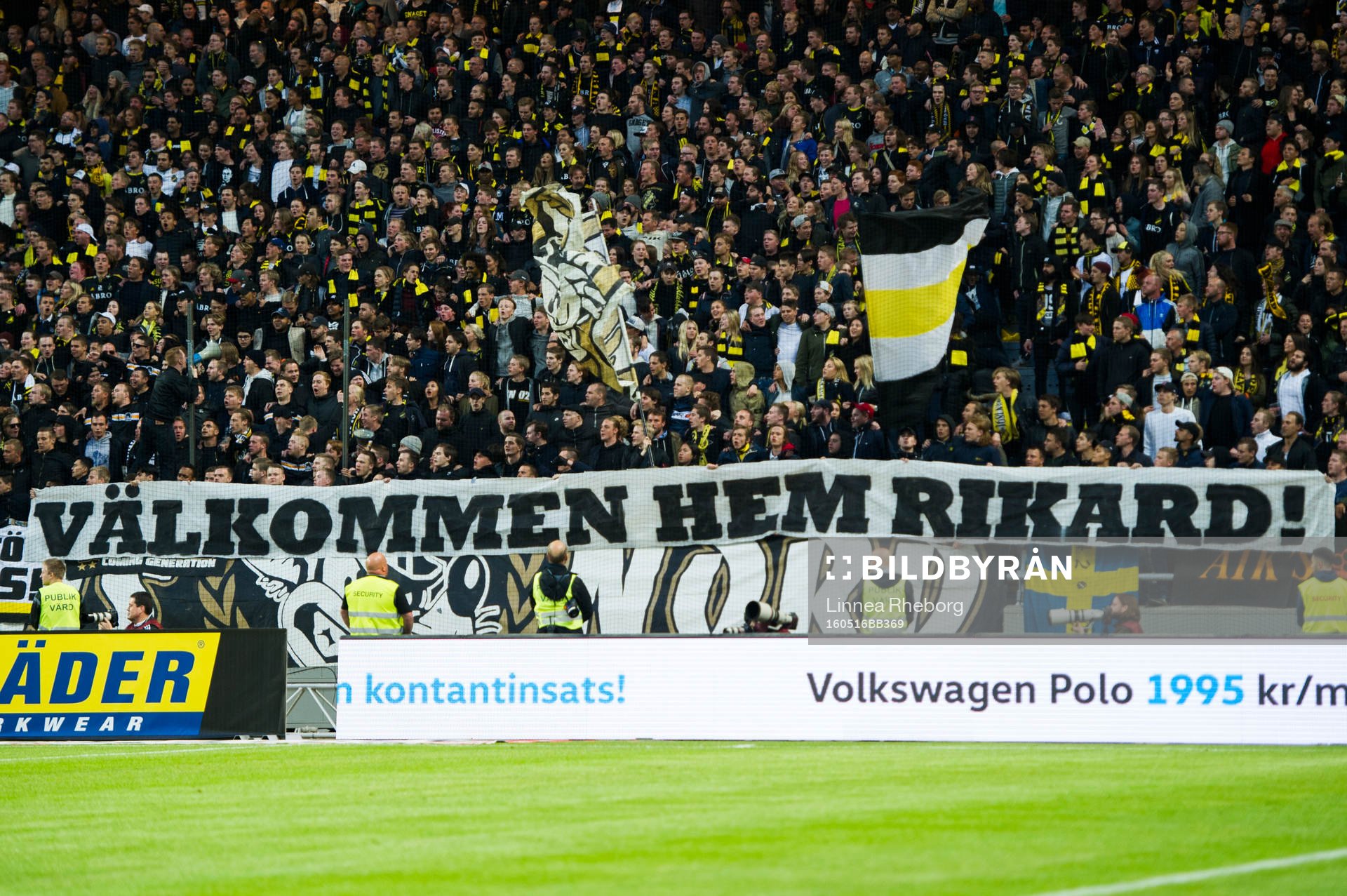 s fans håller upp en banderoll med texten Välkommen hem