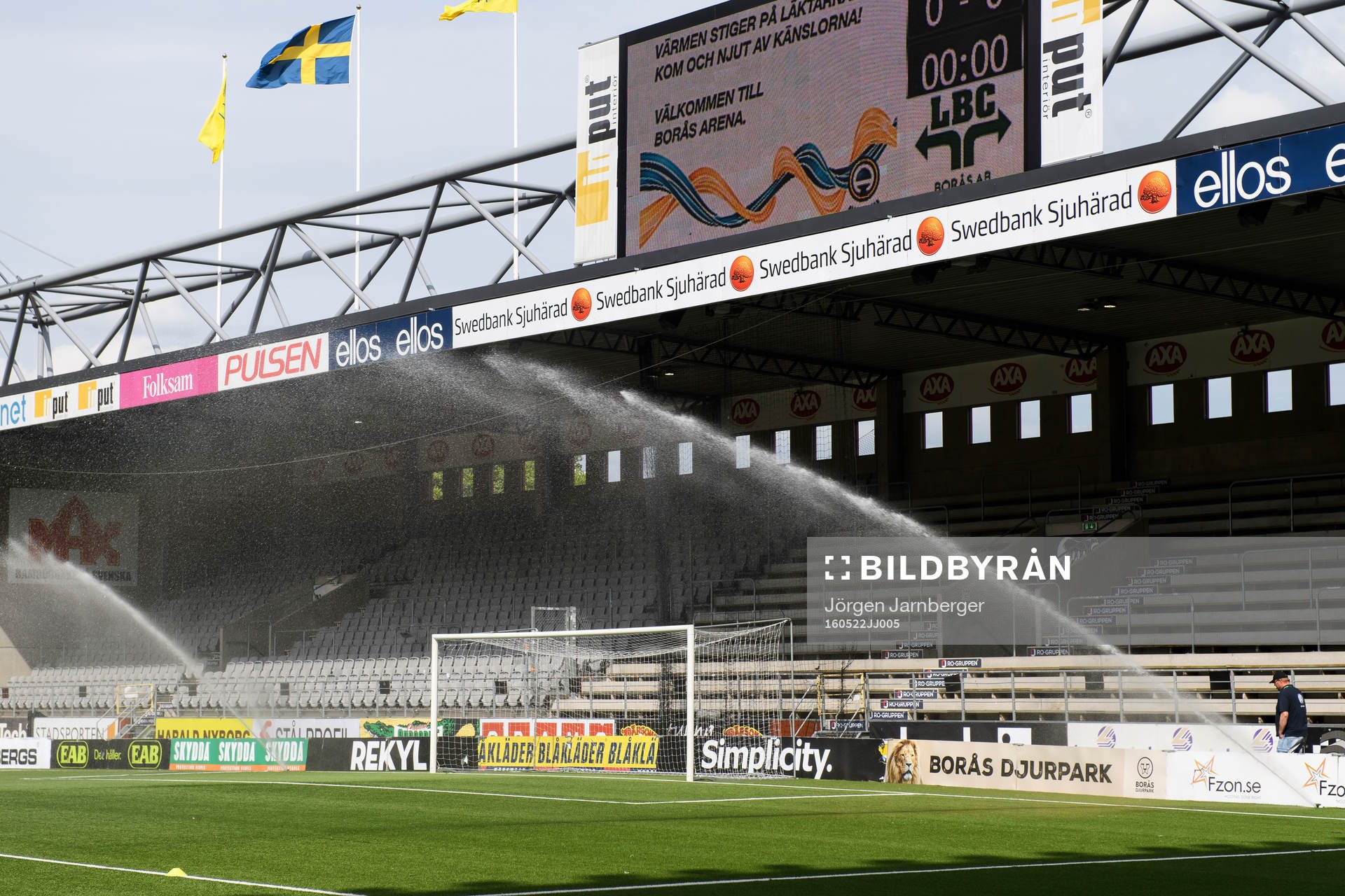 Vattning av konstgräset innan fotbollsmatchen i