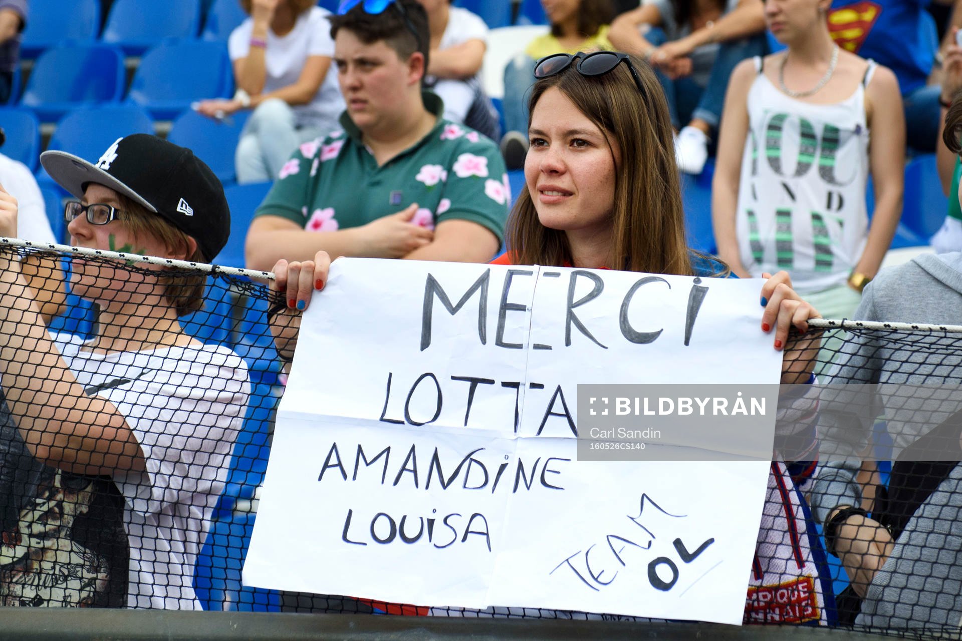 En supporter håller en skylt med texten Merci Lotta