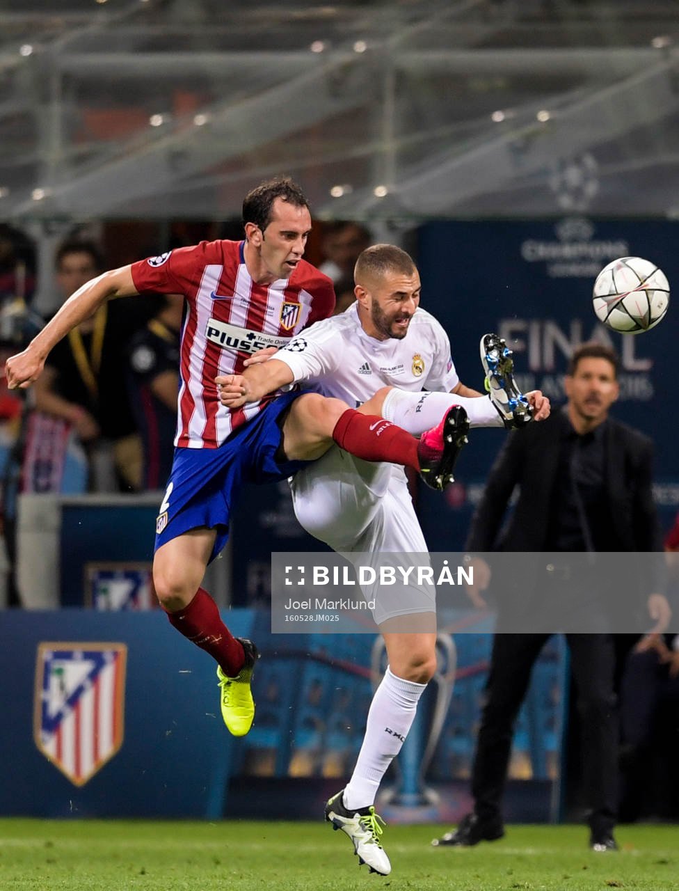 Atletico Madrids Diego Godin i kamp om bollen med Real